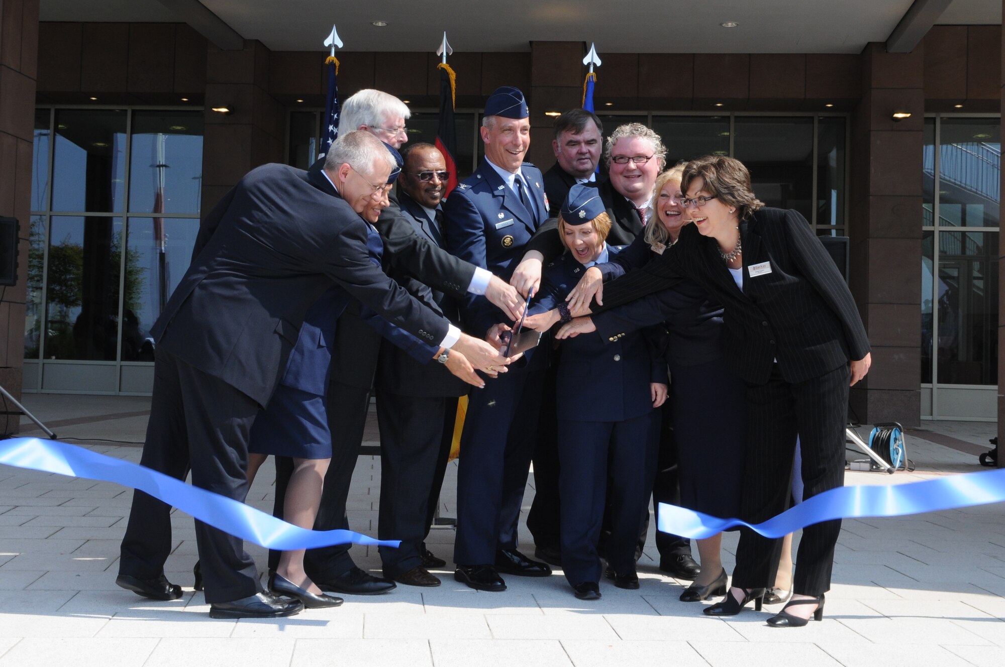 U.S. Air Force Col. Thomas Gould, 435th Air Base Wing commander, helps cut the ribbon to the new Kaiserslautern Military Community Center, Ramstein Air Base, Germany, July 2, 2009. Ramstein Inn’s Visitor's Quarters, Outdoor Recreation, Romano’s Macaroni Grill, a shoppette, Ramstein Tickets and Tours, the Sports Lounge and a German bakery are part of the first phase of openings at the KMCC. (U.S. Air Force Airman 1st Class Caleb Pierce) 