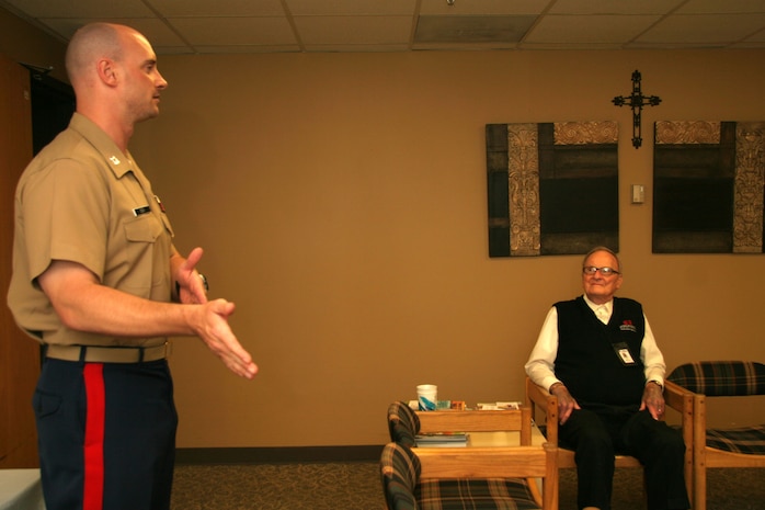 OVERLAND PARK, Kan. - Former Marine Robert Sander (seated) listens as Capt. Gary Cox, executive officer from Recruiting Station Kansas City, details gratitude for Sander's continued service July 7. Sander is a 90-year-old Marine Corps veteran who continues to serve his community through volunteering at the St. Joseph Medical Center, Overland Park, Kan.