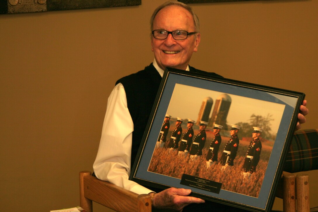 OVERLAND PARK, Kan. - Former Marine Robert Sander holds up a picture of the silent drill platoon July 7. The picture and plaque were gifts from the Marines of Recruiting Station Kansas City in gratitude for Sander's years of service. The 90-year-old Marine Corps veteran continues to serve his community through volunteering at the St. Joseph Medical Center, Overland Park, Kan.