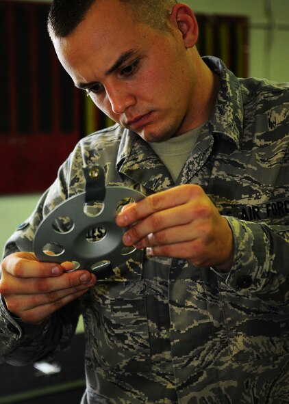 YOKOTA AIR BASE, Japan-- Airman Devin Ballesteros, 374th Operations Support Squadron survival equipment flight, inspects a pilot parachute disk July 2. For safety purposes a parachute is repacked every 180 days. The survival equipment shop repacks approximately six parachutes a week. (U.S. Air Force photo/Airman 1st Class Michael Dillon)