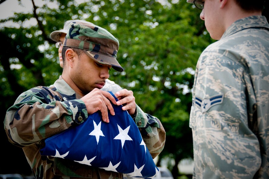 MISAWA AIR BASE, Japan -- Senior Airman Antonio Blair, 35th Comptroller Squadron, dresses the American flag during a retreat ceremony July 2 at the base flag pole. The ceremony was held in honor of Independence Day. (U.S. Air Force photo/Senior Airman Jamal D. Sutter)