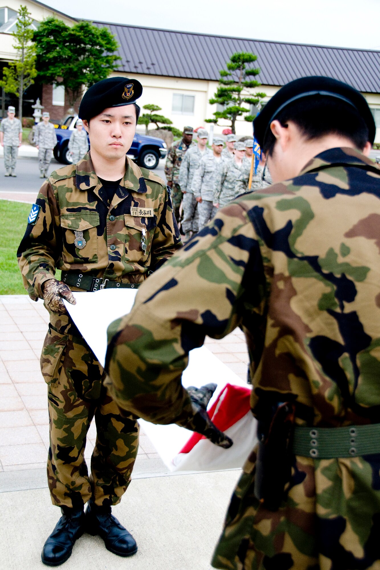 MISAWA AIR BASE, Japan -- Members of the Japan Air Self-Defense Force fold the Japanese flag during a retreat ceremony July 2 at the base flag pole. The ceremony was held in honor of Independence Day but also served as a way to pay respects to the host nation, Japan. (U.S. Air Force photo/Senior Airman Jamal D. Sutter)