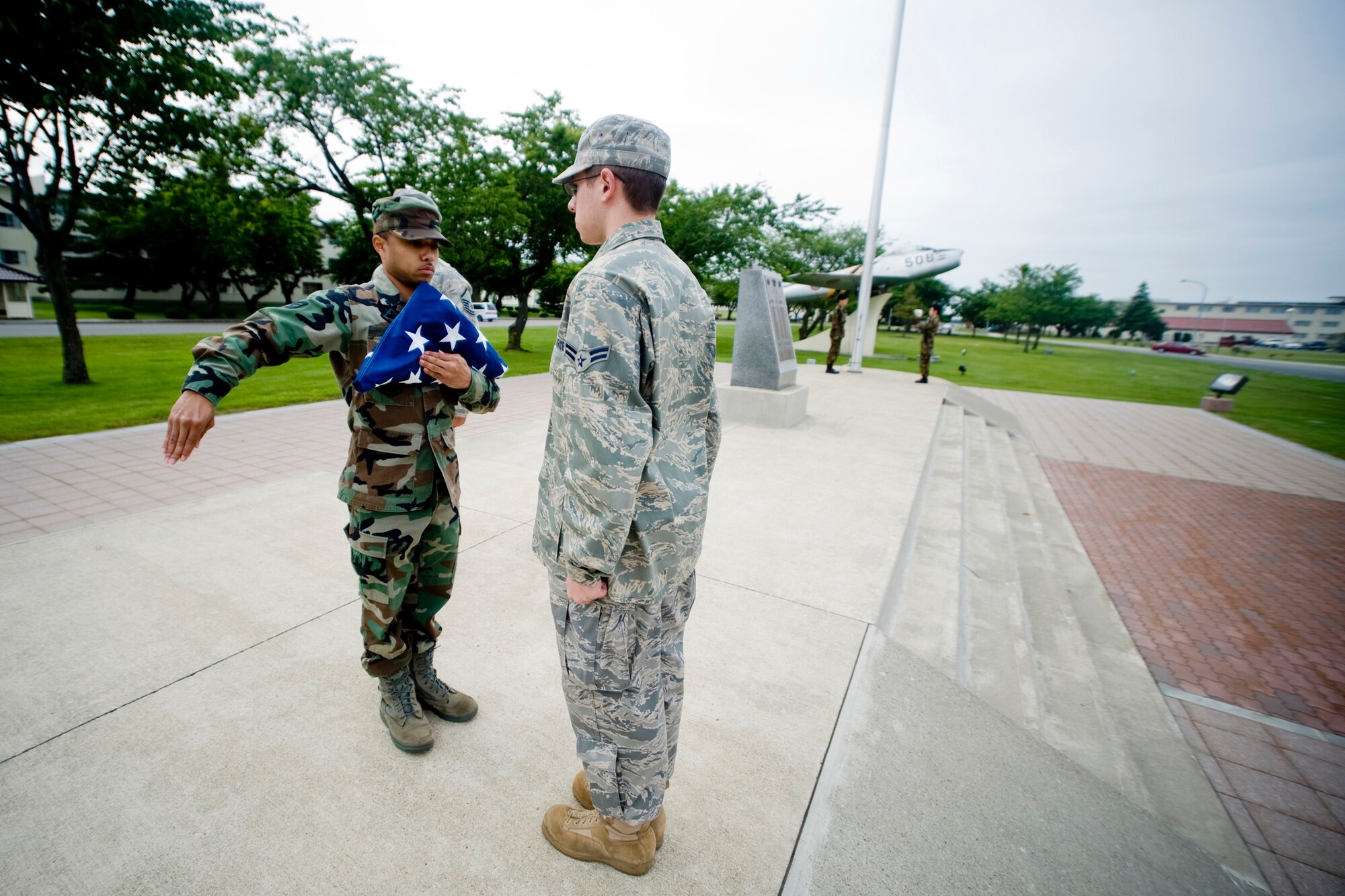 MISAWA AIR BASE, Japan -- Senior Airman Antonio Blair and Airman 1st Class Maxwell Bowes, both of the 35th Comptroller Squadron, participate in a retreat ceremony July 2 at the base flag pole. The ceremony was held to help honor and celebrate the birth of our Nation. (U.S. Air Force photo/Senior Airman Jamal D. Sutter)