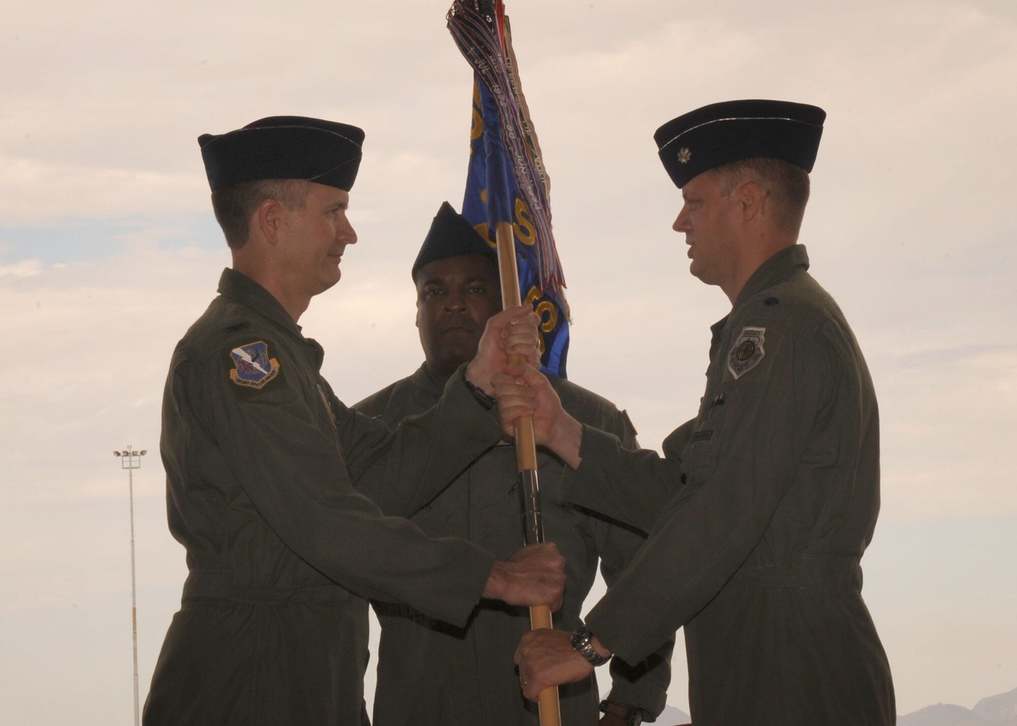 Lt. Col. James D. Kuehn receives the 55th Rescue Squadron guidon from Col. Billy Thompson, the 563rd Rescue Group commander, during the change-of-command ceremony here June 26. Lt. Col. Kuehn assumed command of the 55th RQS from Lt. Col. James McElhenney. (U.S. Air Force photo by Airman 1st Class Brittany Dowdle)