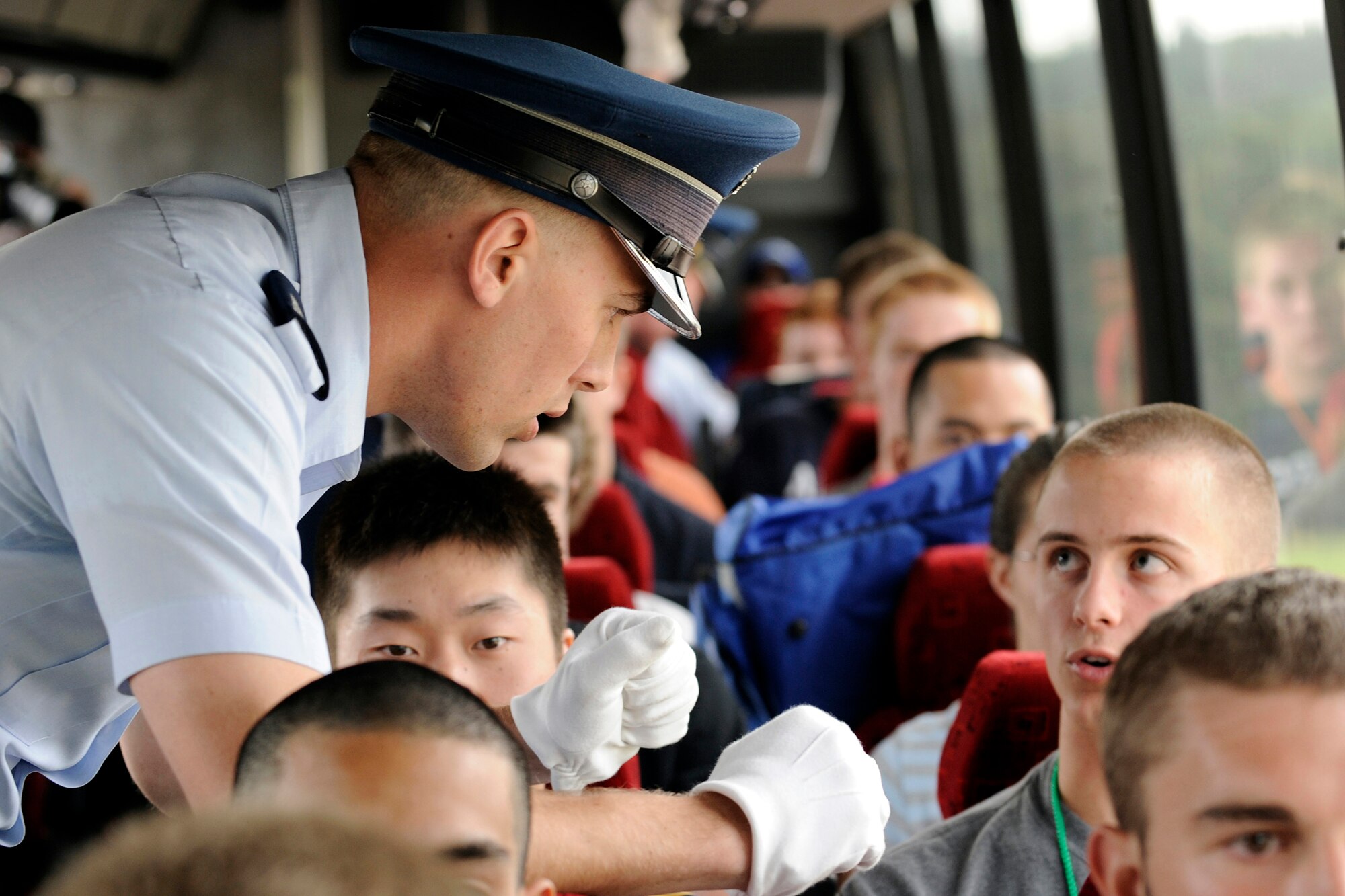 Cadet 2nd Class Nathan Rings addresses a basic cadet during a bus ride from Doolittle Hall to the Cadet Area June 25 at the U.S. Air Force Academy in Colorado Springs, Colo. Basic cadets are directed to sit with their eyes facing forward at all times while on the bus. (U.S. Air Force photo/Dave Ahlschwede)