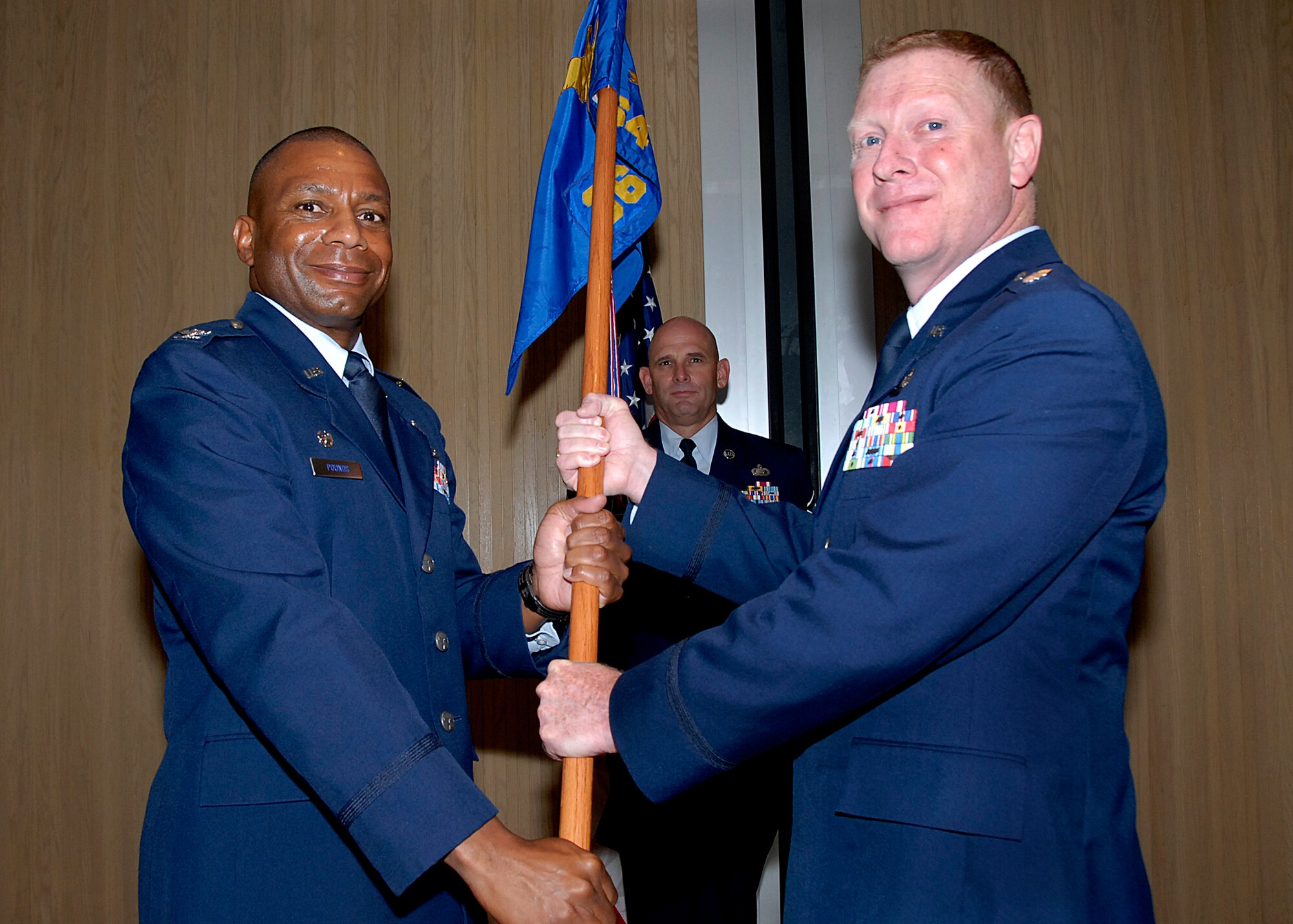 Col. Tony Pounds, 782nd Training Group commander, passes the guidon to the incoming commander of the 364th Training Squadron, Lt. Col. Vincent Hibdon, at a change of command ceremony July 7 at Hangar 1010. Lt. Col. Darryl Neal preceded Colonel Hibdon as commander. (U.S. Air Force photo/ Harry Tonemah)