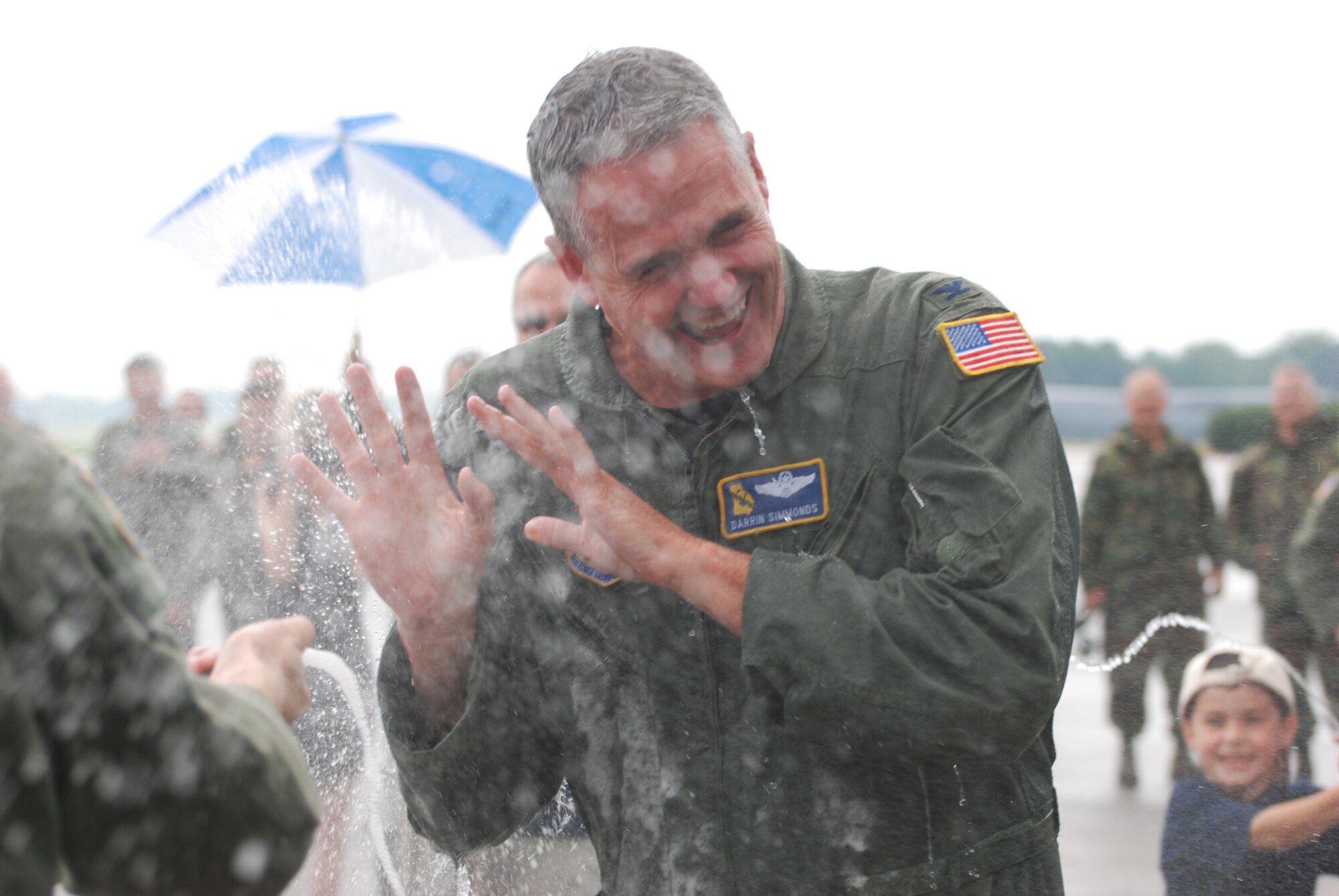Col. Darrin Simmonds, former 94th Operations Support Squadron commander, gets a surprise soaking by flight crew members and his son after the colonel's final flight while assigned to the 94th Operations Group July 6. Colonel Simmonds will take a new position at 22nd Air Force here at Dobbins Air Reserve Base. (U.S. Air Force photo/Tech. Sgt. Bob Martin)