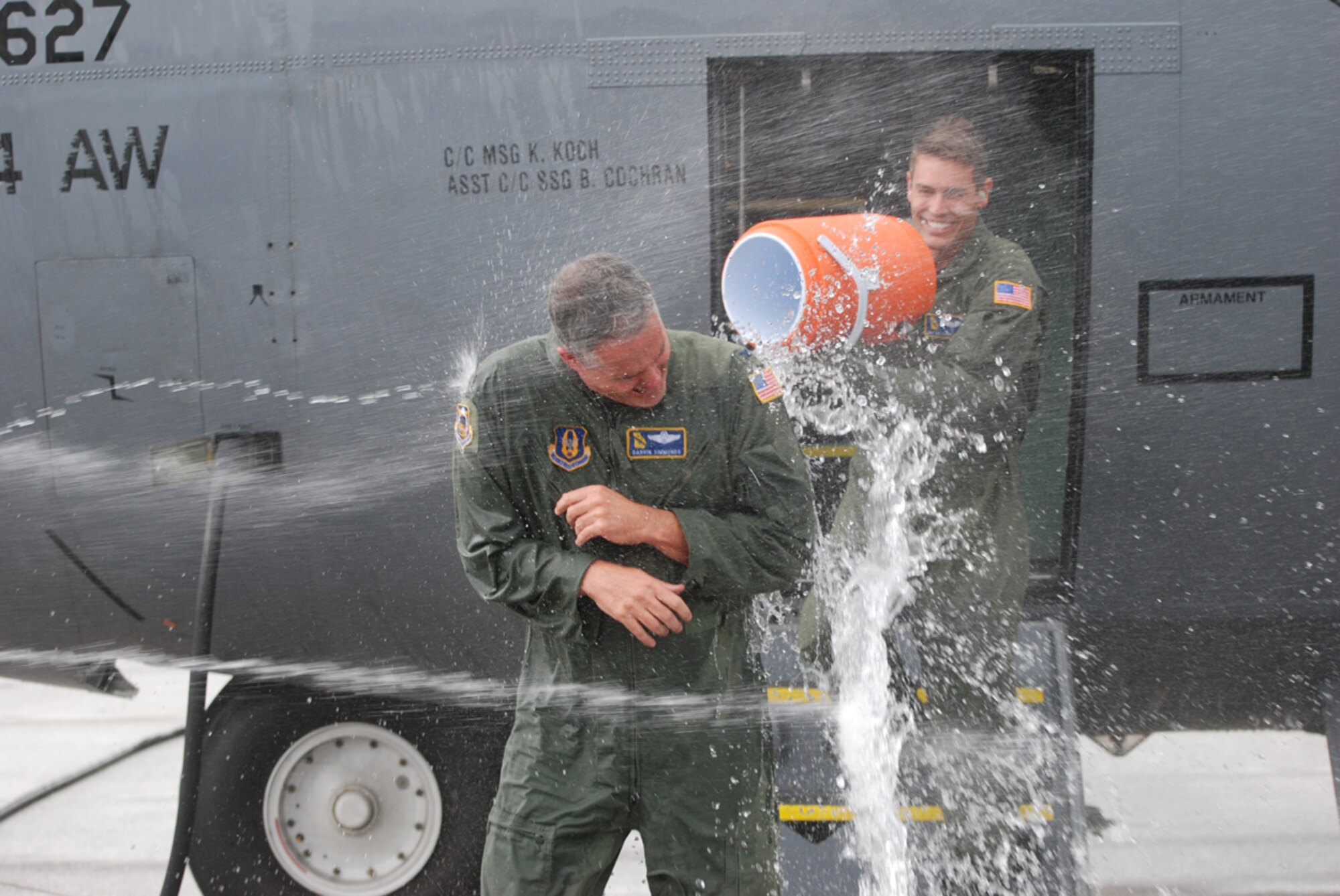 Col. Darrin Simmonds, former 94th Operations Support Squadron commander, gets a surprise soaking by flight crew member, Senior Airman Anthony Toste, 700th Airlift Squadron, after the colonel's final flight while assigned to the 94th Operations Group July 6. Colonel Simmonds will take a new position at 22nd Air Force here at Dobbins Air Reserve Base. (U.S. Air Force photo/Tech. Sgt. Bob Martin)