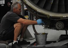 Corey Seeber disconnects the hydraulic lines from the hydraulic pumps on a C-17 engine on Charleston AFB, June 22. The pumps and lines are disconnected so that inspectors can check each piece separately. Mr. Seeber is an aviation maintenance technician with United Airlines. (U.S. Air Force Photo/Senior Airman Katie Gieratz)