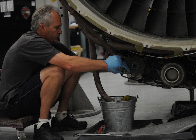 Corey Seeber disconnects the hydraulic lines from the hydraulic pumps on a C-17 engine on Charleston AFB, June 22. The pumps and lines are disconnected so that inspectors can check each piece separately. Mr. Seeber is an aviation maintenance technician with United Airlines. (U.S. Air Force Photo/Senior Airman Katie Gieratz)(Released)
