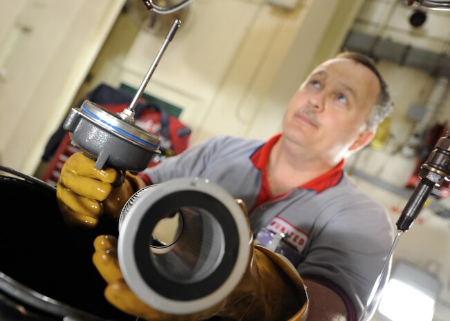 Danny Page inspects the fuel filter for any contamination after a test run on a C-17 engine here June 18. The all-civilian engine shop installs, inspects and repairs five to six engines a month. Mr. Page is an aviation maintenance technician with United Airlines. (U.S. Air Force photo/Senior Airman Katie Gieratz)(Released)