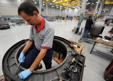 Jerry Zuk repairs a thrust reverser here June 18. Thrust reversers are disassembled into separate pieces and every piece is inspected and repaired before being put back together. The all-civilian engine shop installs, inspects and repairs five to six engines a month. Mr. Zuk is an aviation maintenance technician with United Airlines. (U.S. Air Force photo/Senior Airman Katie Gieratz)