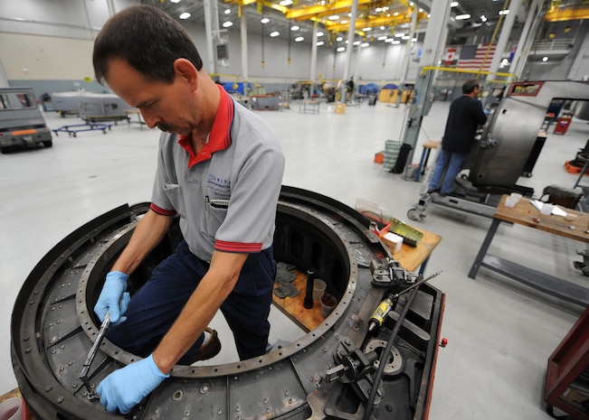 Jerry Zuk repairs a thrust reverser here June 18. Thrust reversers are disassembled into separate pieces and every piece is inspected and repaired before being put back together. The all-civilian engine shop installs, inspects and repairs five to six engines a month. Mr. Zuk is an aviation maintenance technician with United Airlines. (U.S. Air Force photo/Senior Airman Katie Gieratz)(Released)
