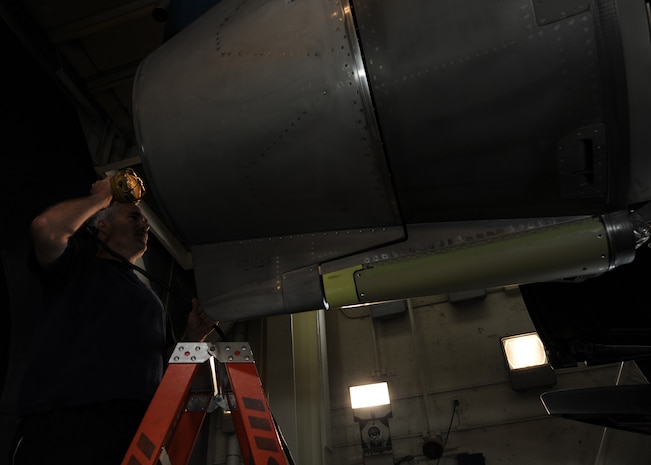 Corey Seeber checks the inside of a C-17 engine here June 18 to make sure there are no leaks in the reverser at the engine test cell. The all-civilian engine shop installs, inspects and repairs five to six engines a month. The thrust reverser is a secondary braking system for the aircraft. Mr. Seeber is an aviation maintenance technician with United Airlines. (U.S. Air Force photo/Senior Airman Katie Gieratz)(Released)

