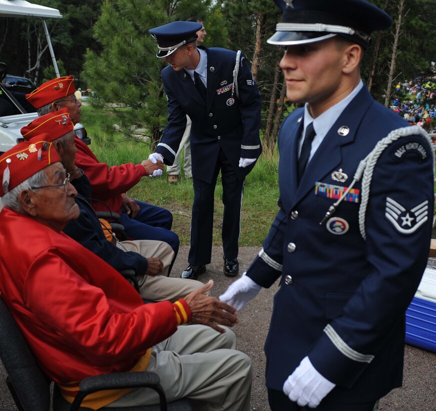 Staff. Sgt. Michael Risse, 28th Honor Guard Non-Commissioned Officer in charge, and (back) Senior Airman Joshua Edwards, 28th Civil Engineer Squadron heat ventilation and air conditioning craftsman, shake the hands of the three last surviving Navajo code talkers at Mt. Rushmore National Memorial during the 2009 Independence Day celebrations. The code talkers used a special code based on the unwritten Navajo language to transmit messages, making it futile for the Japanese enemy to decipher American battle communications about the time and place of attack. The complex syntax and complicated tonal qualities of the Navajo language baffled even the most experienced linguists.  (U.S. Air Force photo/Airman 1st Class Adam Grant)
