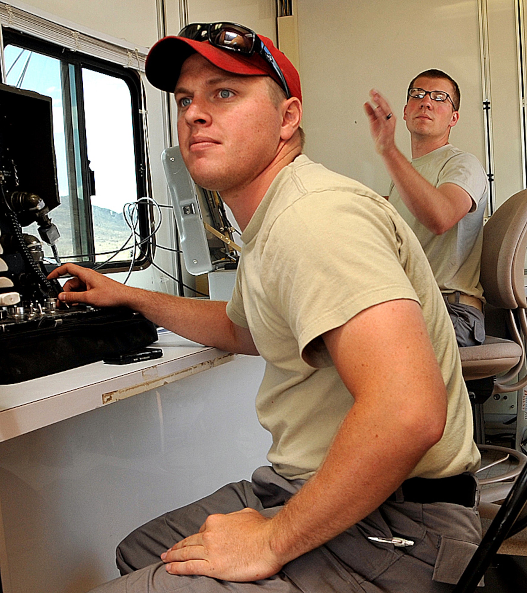 Staff Sgt. Nicholas Worthington (left) and Senior Airman Myles Corbin, Explosive Ordnance Disposal branch, focus on successfully navigating their F6A robot through one of the more difficult obstacles during the Western National Robot Rodeo held here June 22-25. U.S. Air Force photo by Todd Berenger