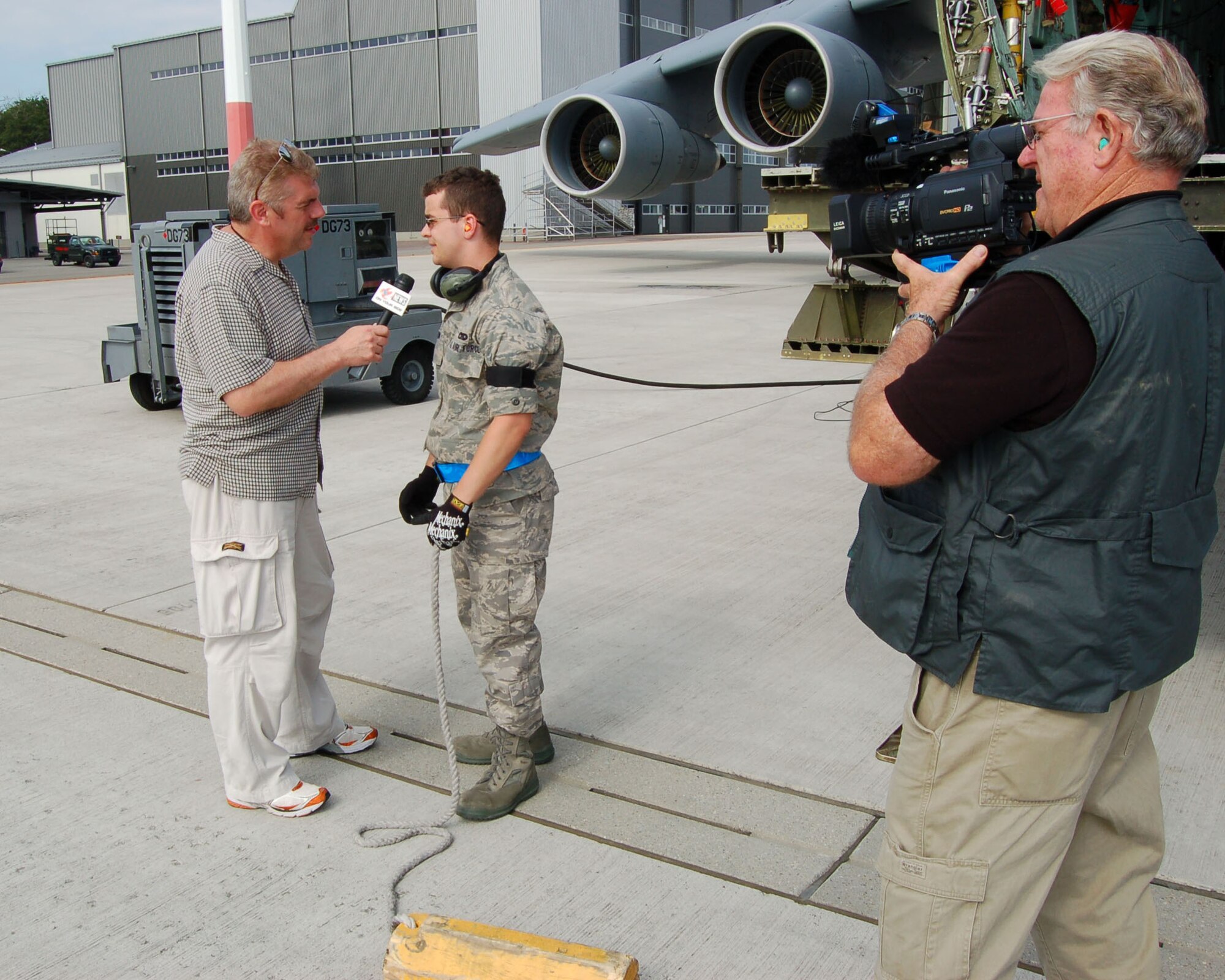 WRIGHT-PATTERSON AIR FORCE BASE, Ohio - WDTN Channel 2, Dayton, reporter Dan Edwards interviews an Airman at Ramstein Air Base, Germany, with photographer Don Hatcher.  The reporter and photographer covered the mission of a C-5 Galaxy belonging to the 445th Airlift Wing June 23-29. The mission they were on began at Wright-Patt and included stops at two U. S. Air Force bases, Germany and Southwest Asia.  (Air Force photo/Maj. Jose Cardenas)