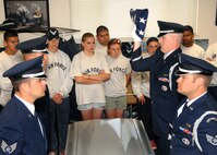 Travis Honor Guardsmen, front left clockwise, Staff Sergeant Richard Kovacs, Staff Sergeant Soren Nelson, Captain John Field and Staff Sergeant Garrett Johnson, perform a flag folding ceremony for JROTC (Junior Reserve Officer Training Corps) Cadets from Del Campo High School, Fair Oaks, California. (U.S. Air Force photo by Civ/Nan Wylie)