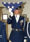 After carrying out a six man flag folding ceremony Air Force JROTC (Junior Reserve Officer Training Corps) Cadet Senior Master Sergeant Steven Comstock does a final inspect and dresses the flag.  The Cadet had the opportunity to get instruction from members of the Travis Honor Guard on a how to perform the flag folding ceremony. Cadet SMSgt Comstock is a member of the JROTC program at Del Campo High School in Fair Oaks, California.  (U.S. Air Force photo by Civ/Nan Wylie)(U.S. Air Force photo by Civ/Nan Wylie)