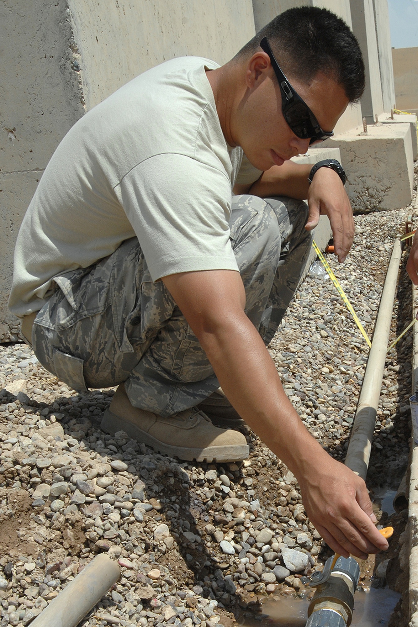 Senior Airman Marvin Katzenmeier, 506th Expeditionary Civil Engineer Squadron utilities journeyman, repairs a water line June 25 at Kirkuk Regional Air Base, Iraq. The water line was damaged while trying to redirect sewer lines underground. Airman Katzenmeier, a Denver native, is deployed to the northern Iraqi air base from the Air Force Reserve's 302nd Civil Engineer Squadron at Peterson Air Force Base, Colo. (U.S. Air Force photo/Staff Sgt. Eunique Stevens)