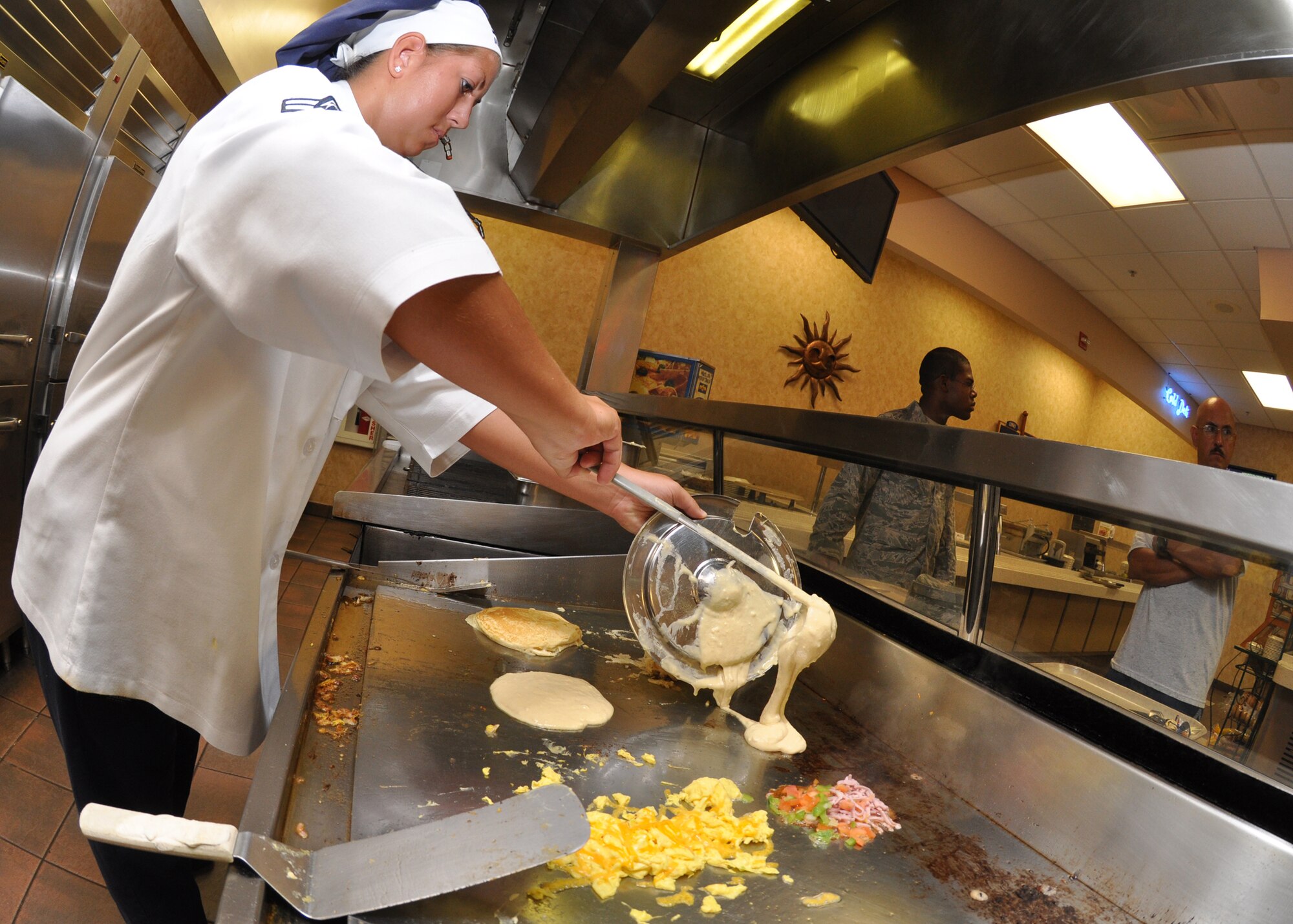 An Airman serves up breakfast at The Breeze dining facility July 7at Eglin Air Force Base.  The dining facility, fitness center and clubs used to be part of the 96th Services Squadron.  As of June 30, the Services Squadron has merged with the 96th Mission Support Squadron to become the 96th Force Support Squadron.  (U.S. Air Force photo/Airman Anthony Jennings) 