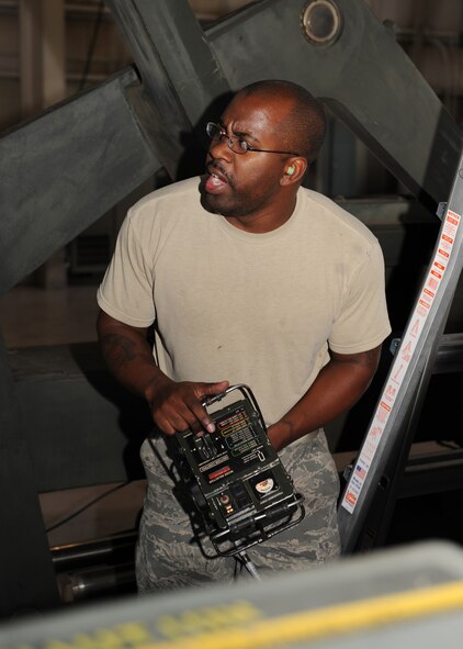 DYESS AIR FORCE BASE, Texas – Staff Sgt. Jamar Hughing, 7th Aircraft Maintenance Squadron, shouts out as he confirms with one of his fellow weapons loaders the alignment on a trailer load is in place, June 26 at the Dyess load barn.  All weapons loaders must be evaluated and go through numerous qualifications every month to ensure all skills are up to date and their teams work efficiently together. (U.S. Air Force photo by Senior Airman Jennifer Romig)