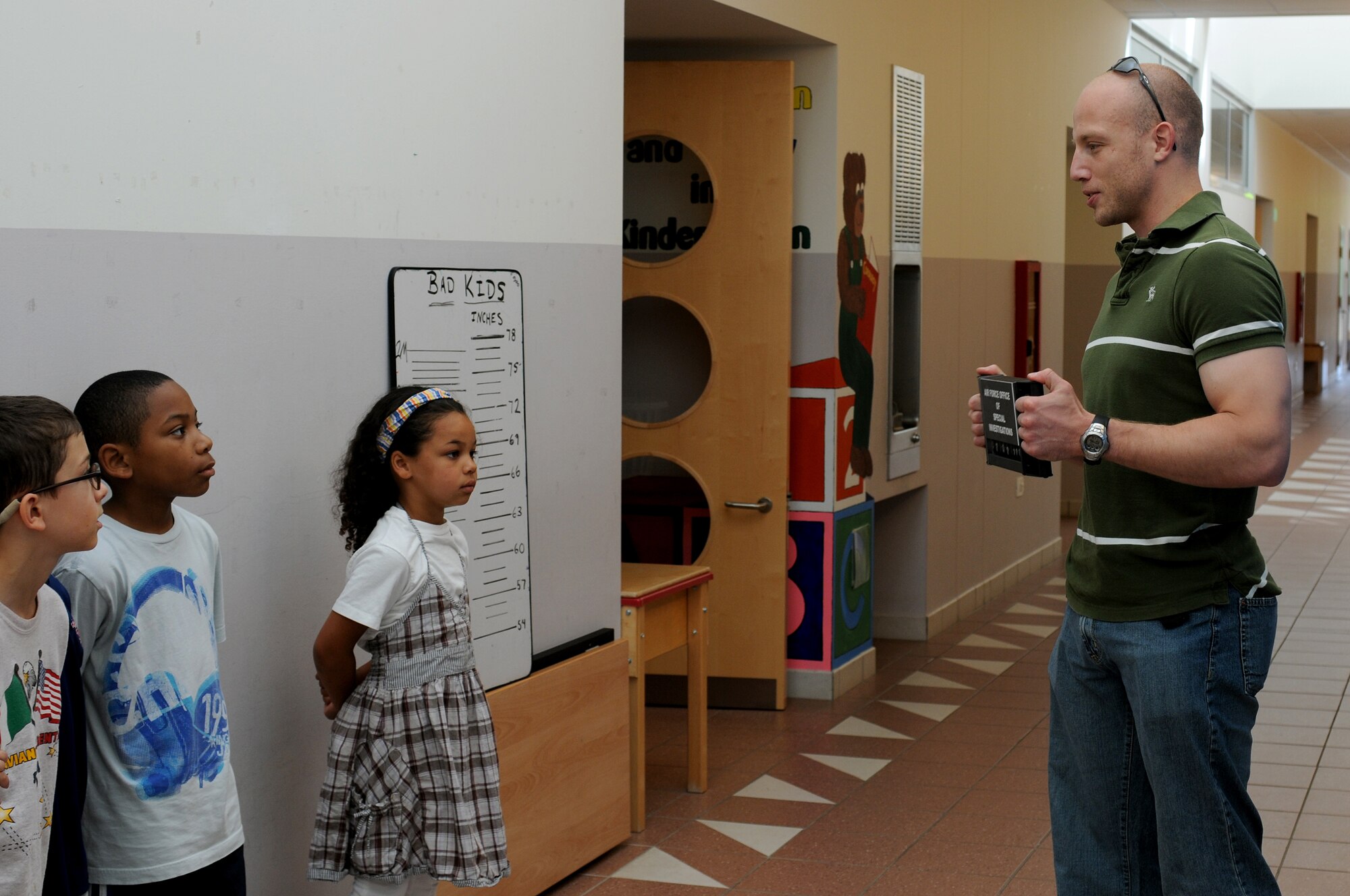 Special Investigator Jarrett Parker, from the Office of Special Investigations, talks to children about mug shots July 1 at the Aviano Air Base Elementary School.  Every summer the elementary school hosts a summer enrichment program for children in kindergarten through fifth grade.   (U.S. Air Force photo/Airman 1st Class Ashley Wood)