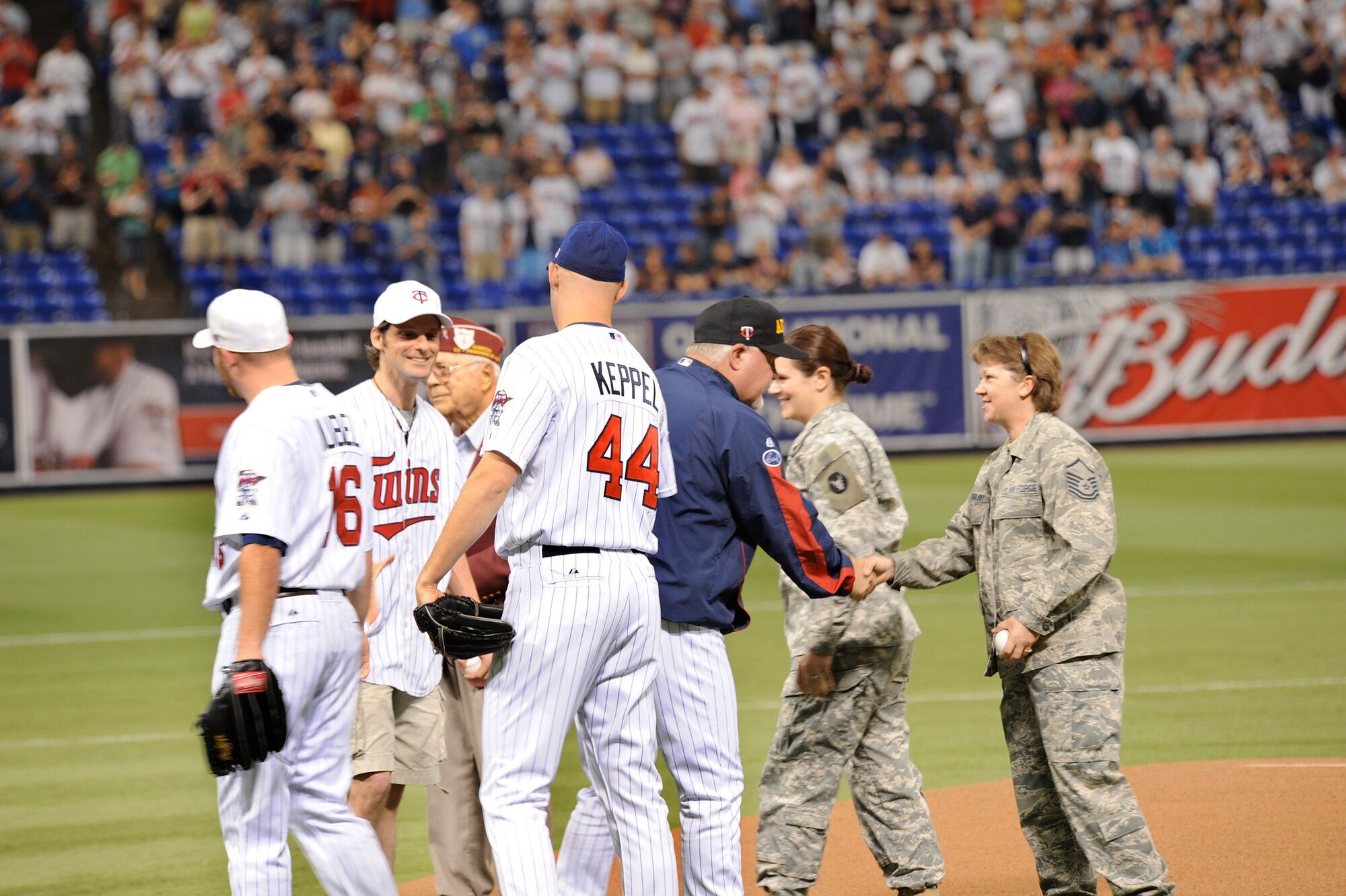 Master Sgt. Jamy Tikalsky (far right), a logistics planner with the 133rd Logistics Readiness Squadron, shakes hands with Twins Manager Ron Gardenhire after throwing out the ceremonial first pitch at a Minnesota Twins game along with other military veterans on the mound during the Twins? seventh annual Armed Services Appreciation Day on July 5, 2009. Master Sgt. Tikalsky recently completed a tour in Afghanistan supporting Operation Enduring Freedom along with hundreds of other Airmen from the Minnesota Air National Guard?s 133rd Airlift Wing from St. Paul, Minn. The Minnesota Twins used the Fourth of July weekend game to honor all members of the armed services and their families during a game with the Detroit Tigers. The Twins defeated Detroit 2-6 in front of more than 33,000 fans. United States Air Force photo by Tech. Sgt. Erik Gudmundson (Released)