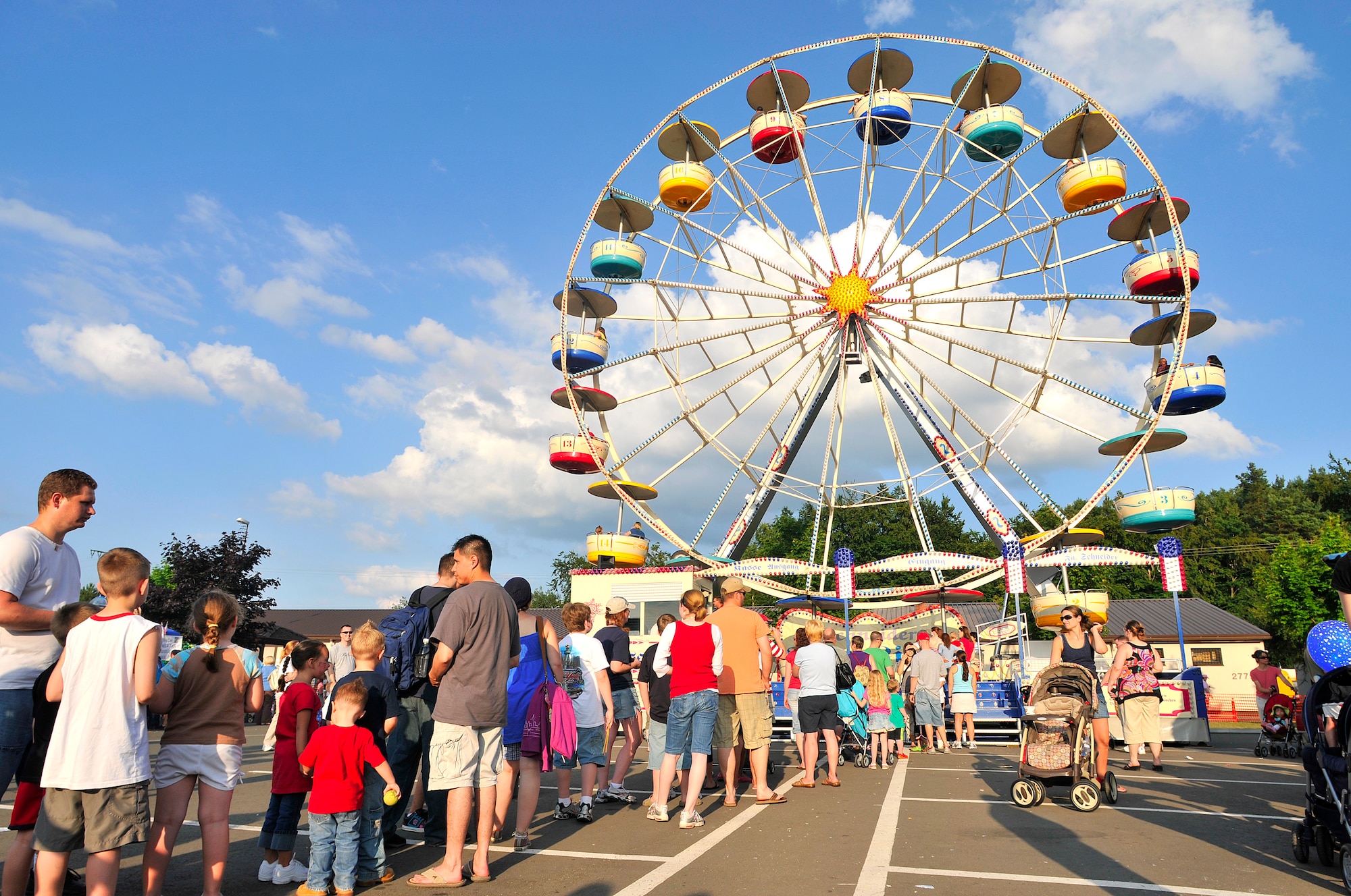 Military and civilian members stand in line to ride a ferris wheel at the Rockin' Fourth of July celebration, July 4, 2009, Kapaun Air Station, Germany. Kaiserslautern Military Community members celebrated the event with games, rides and concerts and ended the night with fireworks. (U.S. Air Force photo by Staff Sgt. Stephen J. Otero)