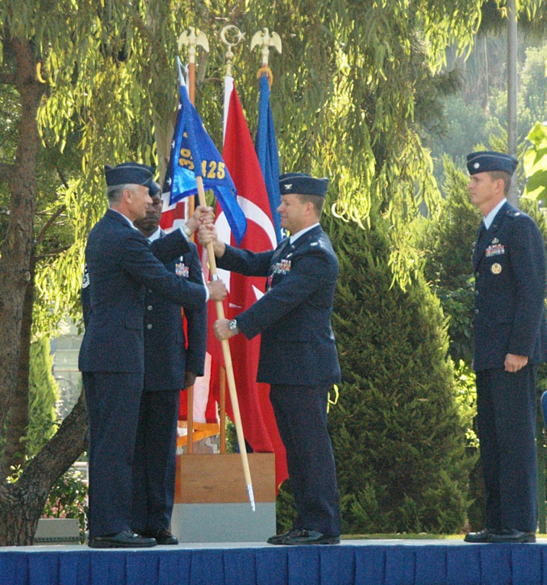 Col. Phil McDaniel, 39th Air Base Wing commander, accepts the 425th Air Base 
Group guidon from Col. Richard Robel, 425th ABG commander, as he relinquishes 
command Wednesday, July 1, 2009 during the redesignation ceremony at the Bayrakli Parade Grounds in Izmir, Turkey. Lt. Col. William Foster waits to accept the 425th Air Base Squadron guidon from Colonel McDaniel as he assumes command. Colonel Foster is the former Chief of Officer Force Management Policy Section, Headquarters United States Air Force, Pentagon. (U.S. Air Force photo/Tanju Varlikli)
