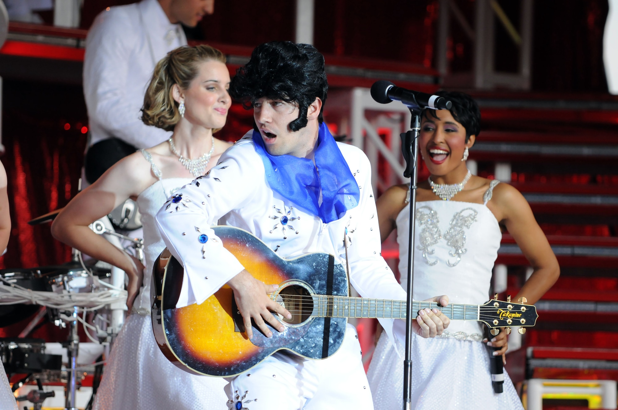 Senior Airman Johnny Magbanua performs an impersonation of Elvis Presley July 4 as part of Tops in Blue, the Air Force’s traveling performance group.  The concert was part of the American Independence Day celebration held at RAF Feltwell.  (U.S. Air Force photo by Staff Sgt. Austin M. May)