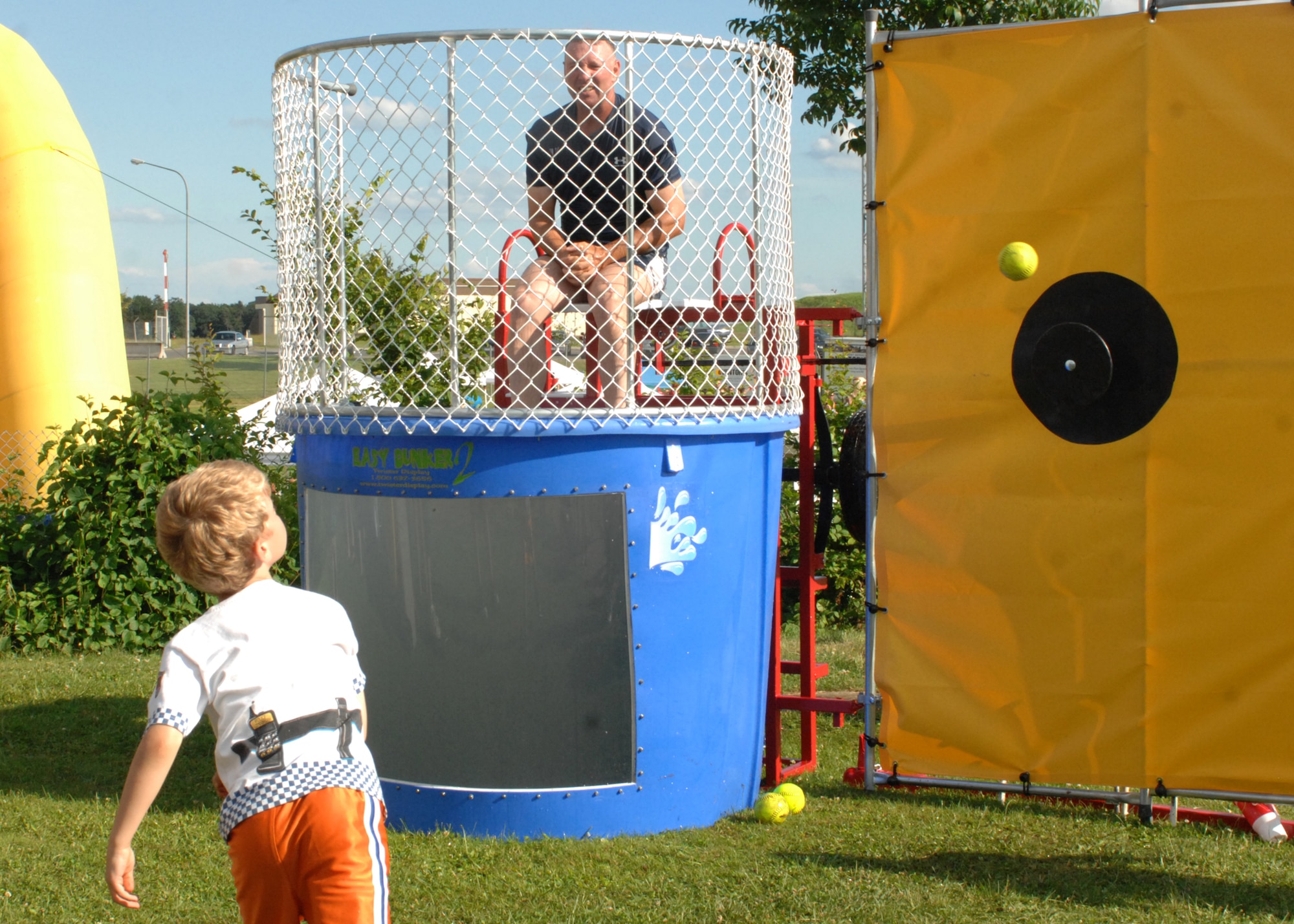 SPANGDAHLEM AIR BASE, Germany -- A young saber takes a shot at Col. Tip Wight, 52nd Fighter Wing commander, at the dunk booth July 4 at Spangdahlem Air Base’s Super Saber Day.  Super Saber Day included free food, music, activity booths, and a fireworks finale with 1,800 people in attendance and 3,100 meals being served. (U.S. Air Force photo by Senior Airman Jenifer H. Calhoun) 