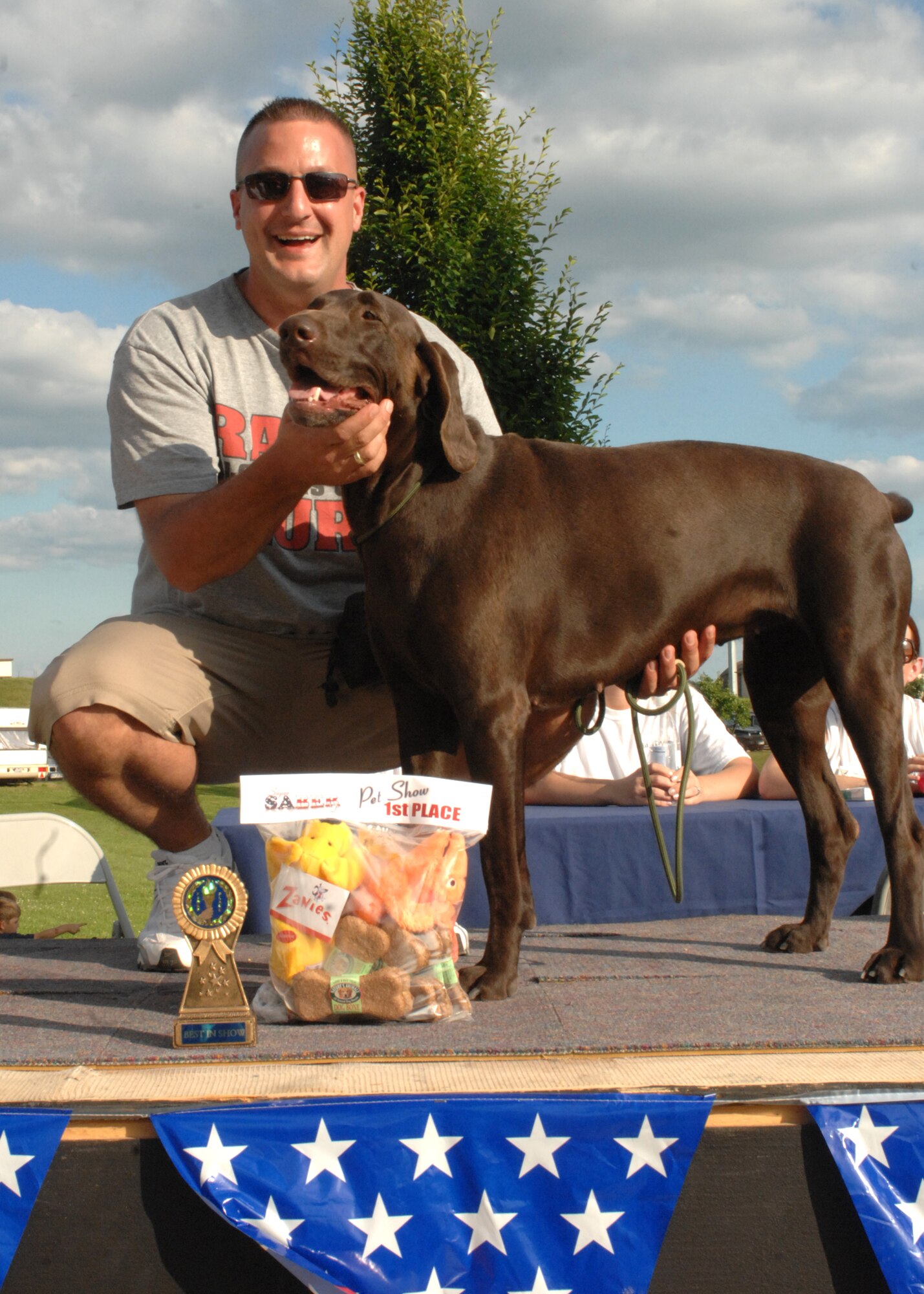SPANGDAHLEM AIR BASE, Germany -- Master Sgt. Matthew Sabo, 372nd Training Squadron Detachment 17, and Jackie pose with their prizes at the pet show July 4 during Spangdahlem Air Base’s Super Saber day.  Jackie, a chocolate Labrador, took best in show beating out 28 other competitors competing in categories such as cutest, best look alike, best trick, best dressed and best behaved at the pet show. (U.S. Air Force photo by Senior Airman Jenifer H. Calhoun)