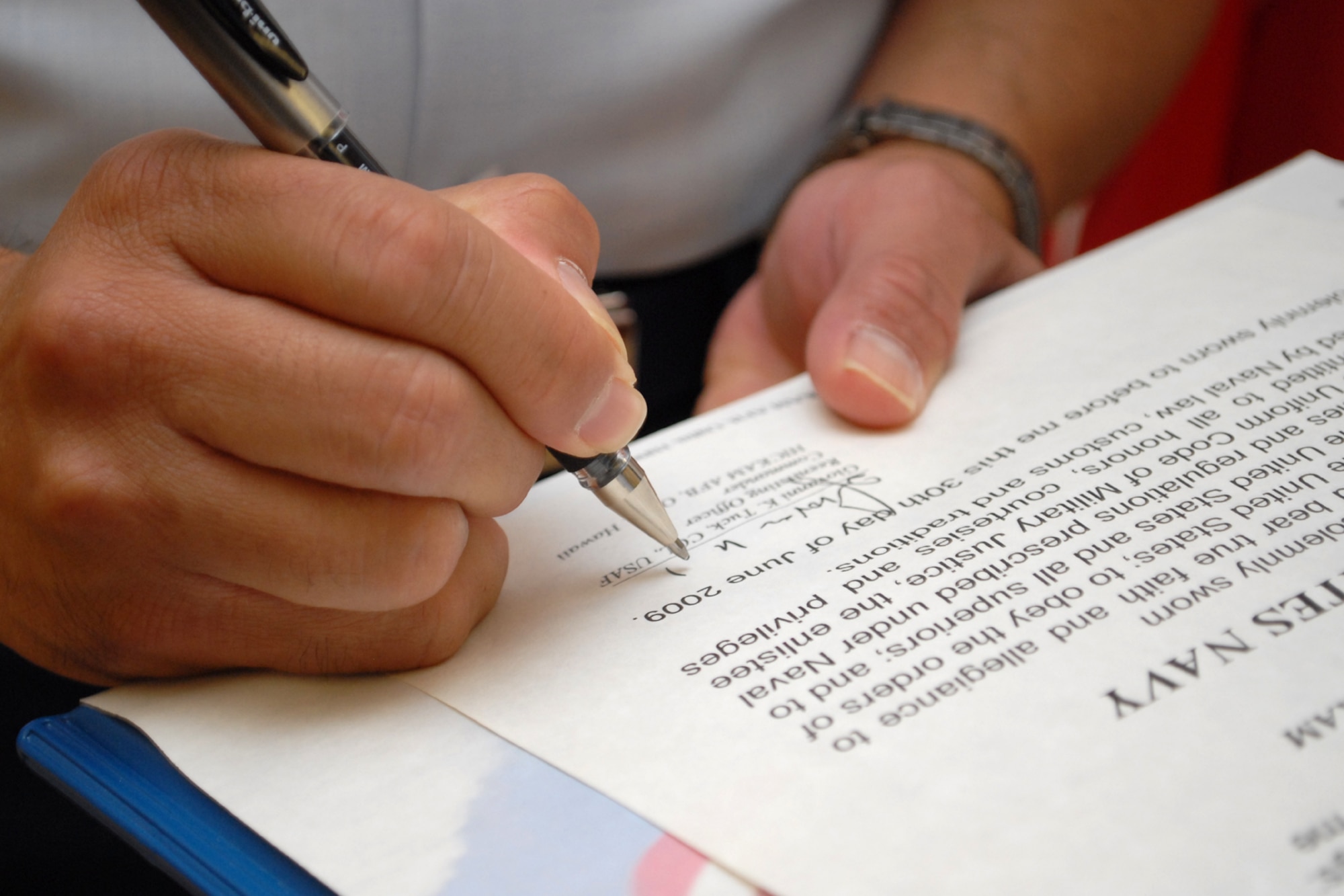 HICKAM AIR FORCE BASE, Hawaii -- Col. Giovanni Tuck, 15th Airlift Wing commander, signs reenlistment paperwork for U.S. Navy Petty Officer 1st Class Jarrod A. Hickam, a submarine machinist?s mate aboard the USS Buffalo (SSN 715), during a ceremony in the headquarters building June 30. While in Pearl Harbor, Petty Officer Hickam wanted to have the commander of the base bearing his family?s namesake reenlist him. Petty Officer Hickam is the great-great-nephew Lt. Col. Horace Hickam. Following orders published by Gen. Douglas MacArthur, War Department Chief of Staff, a new flying field on the island of Oahu was dedicated and named "Hickam Field" May 31, 1935. Petty Officer Hickam is one of three petty officer first classes leading the auxiliary division and serves as the ship?s assistant quality assurance officer.  (U.S. Air Force photo by Staff Sgt. Mike Meares)