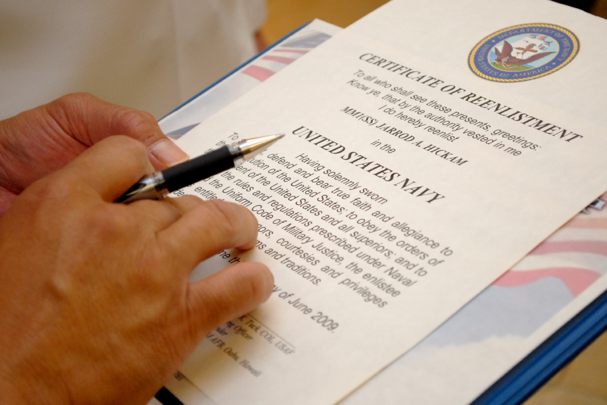 HICKAM AIR FORCE BASE, Hawaii -- Col. Giovanni Tuck, 15th Airlift Wing commander, reads reenlistment paperwork for U.S. Navy Petty Officer 1st Class Jarrod A. Hickam, a submarine machinist?s mate aboard the USS Buffalo (SSN 715), during a ceremony in the headquarters building June 30. While in Pearl Harbor, Petty Officer Hickam wanted to have the commander of the base bearing his family?s namesake reenlist him. Petty Officer Hickam is the great-great-nephew Lt. Col. Horace Hickam. Following orders published by Gen. Douglas MacArthur, War Department Chief of Staff, a new flying field on the island of Oahu was dedicated and named "Hickam Field" May 31, 1935. Petty Officer Hickam is one of three petty officer first classes leading the auxiliary division and serves as the ship?s assistant quality assurance officer.  (U.S. Air Force photo by Staff Sgt. Mike Meares)