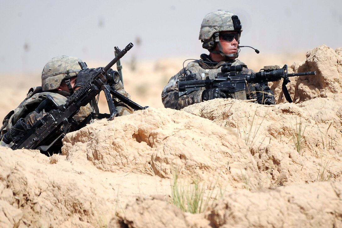 U.S. Army Pfc. Kevin Harrison, left, and Spc. Matthew Luce observe the objective while manning a support position during a joint air assault operation planned and led by Iraqi forces in the Ma'dain area east of Baghdad, Iraq, June 26, 2009.