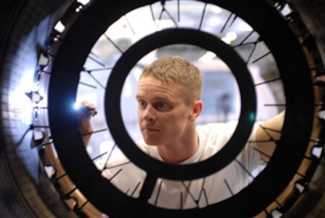 Petty Officer 2nd Class Steven Aldridge inspects the after-burner of an ...