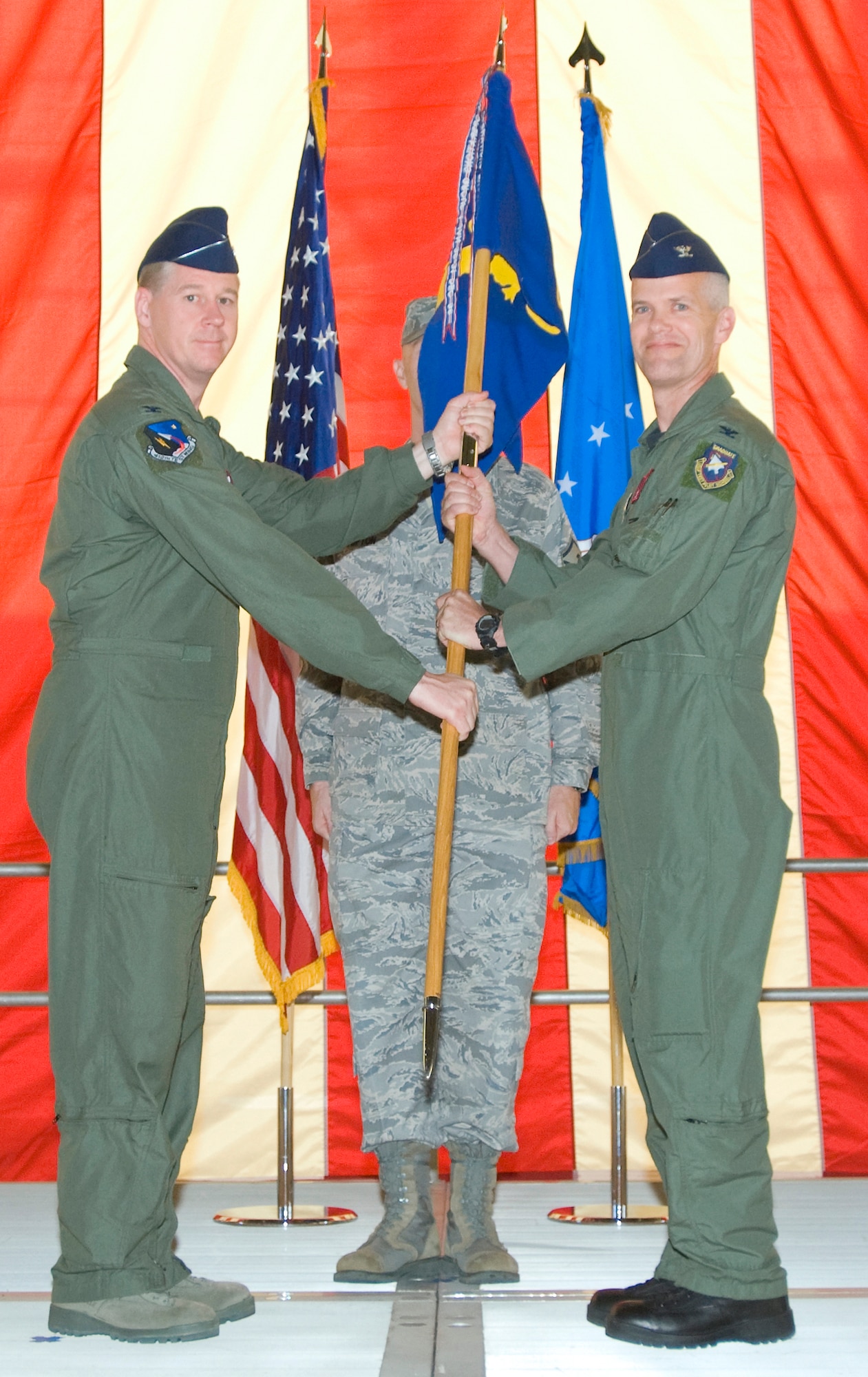 Col. William Thornton(left), 412th Test Wing commander, hands Col. Colin Miller the 412th Operations Group guidon during a change of command ceremony July 2. (Air Force photo/Heather Anhalt)