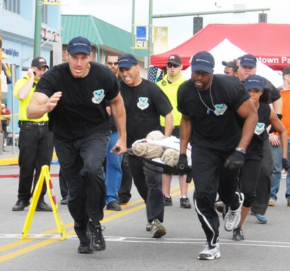 The Double Deuces carry a 200-pound dummy during the litter carry event at the 2009 Hero Games June 27 in downtown Anchorage, Alaska. The games pitted military members, including Reserve, active duty and Guard, against firefighters, police officers and other local first responders. Events included an obstacle course, water balloon volleyball, tricycle race, tug-of-war, litter carry, and a bucket brigade vehicle tow. From left: Lt. Col. Dave "Piff" Piffarerio, Tech. Sgt. Jorge "The Hellion" Mendoza, Staff Sgt. Spencer "The Guns" Walcott, and Staff Sgt. Danielle "La Femme Fatale" Foster. The team placed fourth out of 12 teams in the first-ever event of its kind here. (U.S. Air Force photo/Staff Sgt. Andrea Knudson)