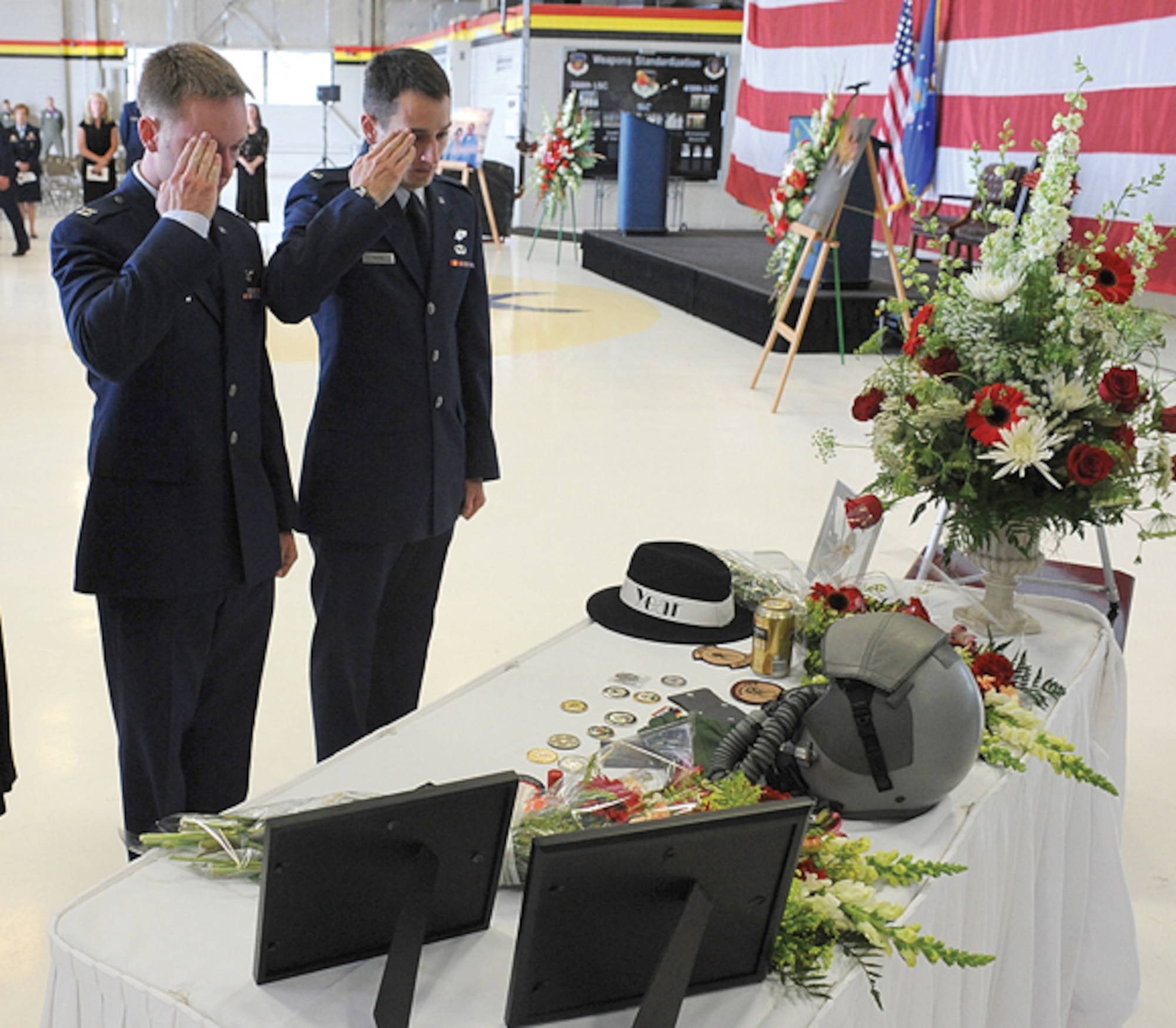 Capt. Benjamin Meier, left, and 1st Lt. Mike Pacini, both of the 421st Fighter Squadron, salute in remembrance of Capt. George Houghton, 421st FS, at a memorial service held at Hill AFB in his memory June 26.  (U.S. Air Force photo by Alex R. Lloyd)