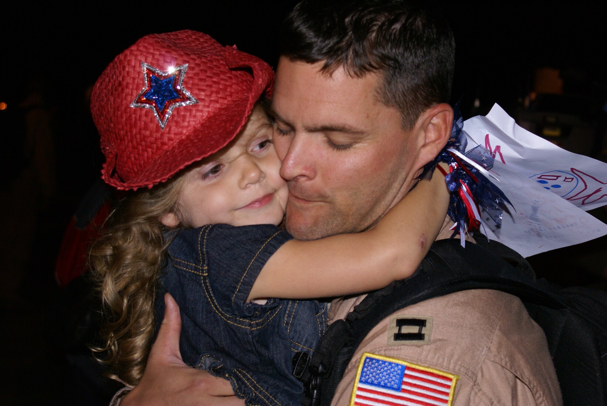 Capt. Michael Capozzi, a pilot with the 7th Airlift Squadron, gets a big hug from his daughter during the squadron's return to McChord July 7. More than 150 Airmen from the squadron were greeted by family and friends here after more than four months deployed in support of Operations Enduring and Iraqi Freedom. The 7th AS Airmen deployed as the 817th Expeditionary Airlift Squadron, flying missions throughout the combat zone and Europe. (U.S. Air Force photo/Master Sgt. Dean Miller)