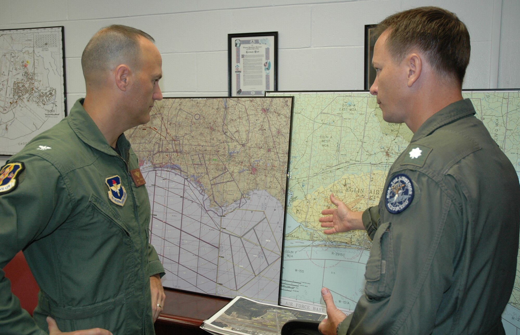 Navy Captain Mike Saunders, projected 33rd Operations Group deputy commander, discusses Eglin range capabilities with Navy Commander Mike Williams, F-35 Joint Site Activation Task Force. Prior to transitioning the 33rd Fighter Wing to Air Education and Training command Oct. 1, the SATAF office stood up to facilitate all the requirements needed to begin F-35 Joint Strike Fighter training at Eglin. Captain Saunders is the first senior leadership to arrive with assignment orders to the future school house designed to train Air Force, Navy, Marine and international partner pilots and maintainers. (U.S. Air Force photo/Chrissy Cuttita)