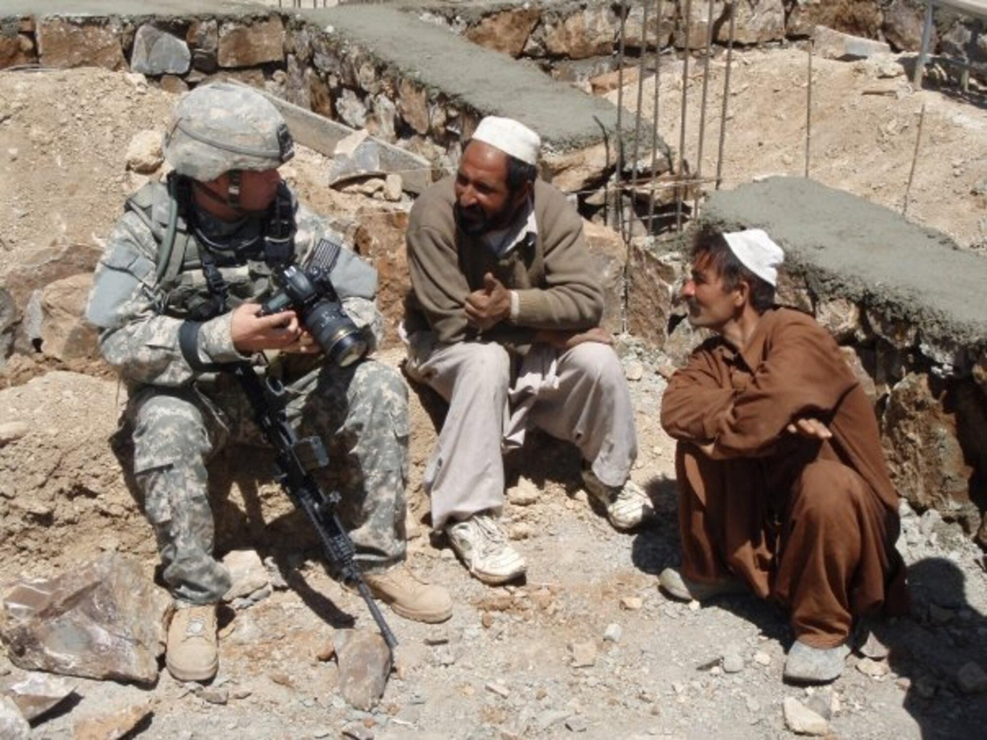 Staff Sgt. Shawn Weismiller talks to Afghan men in 2009. Sergeant Weismiller is an aerial combat photojournalist assigned to the 1st Combat Camera Squadron from Charleston Air Force Base, S.C. (U.S. Air Force photo/ Staff Sgt. Stacia Zachary)