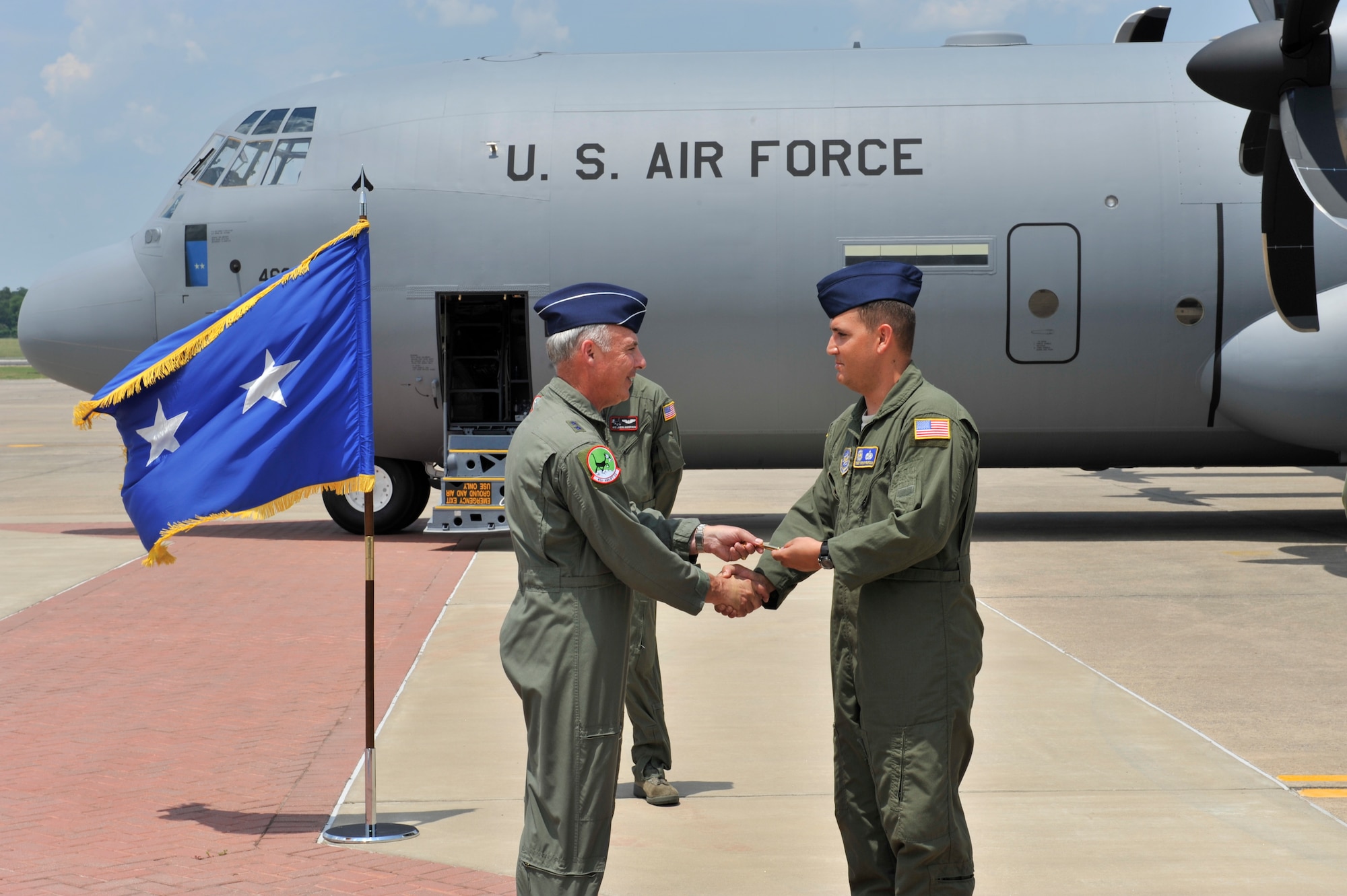 Maj. Gen. Winfield W. Scott III, 18th Air Force commander, hands the key to Little Rock Air Force Base's newest C-130J aircraft to Tech. Sgt. Stephen Pearson, a 19th Aircraft Maintenance Squadron flying crew chief, July 7. Gen. Scott piloted the aircraft during its delivery from the Lockheed-Martin plant in Marietta, Ga. (U.S. Air Force photo by Staff Sgt. Chris Willis)