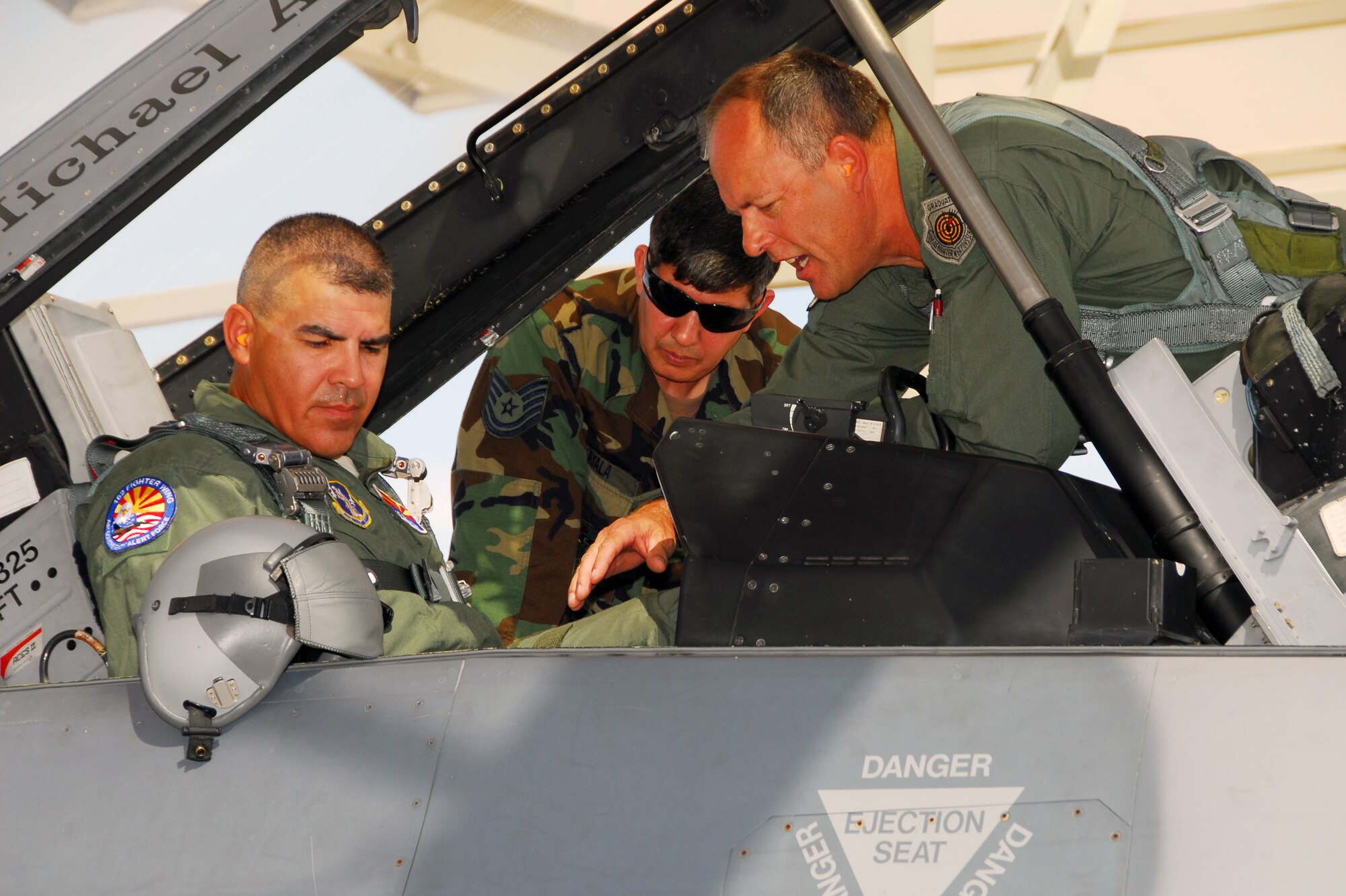 Maj. Gen. Hugo E. Salazar (left), Adjutant General and Commanding General of the Arizona National Guard, gets familiar with the back seat of an F-16D Fighting Falcon on the 162nd Fighter Wing flightline before taking a flight July 7. Col. Greg Stroud (right), the wing commander, ensured the general was safely connected to the aircraft with help from crew chief Tech. Sgt. Arsenio Ayala (center). The experience was instrumental in familiarizing General Salazar with the wing's full-time mission to train U.S. and partner nation fighter pilots. (Air National Guard photo by Master Sgt. Dave Neve)