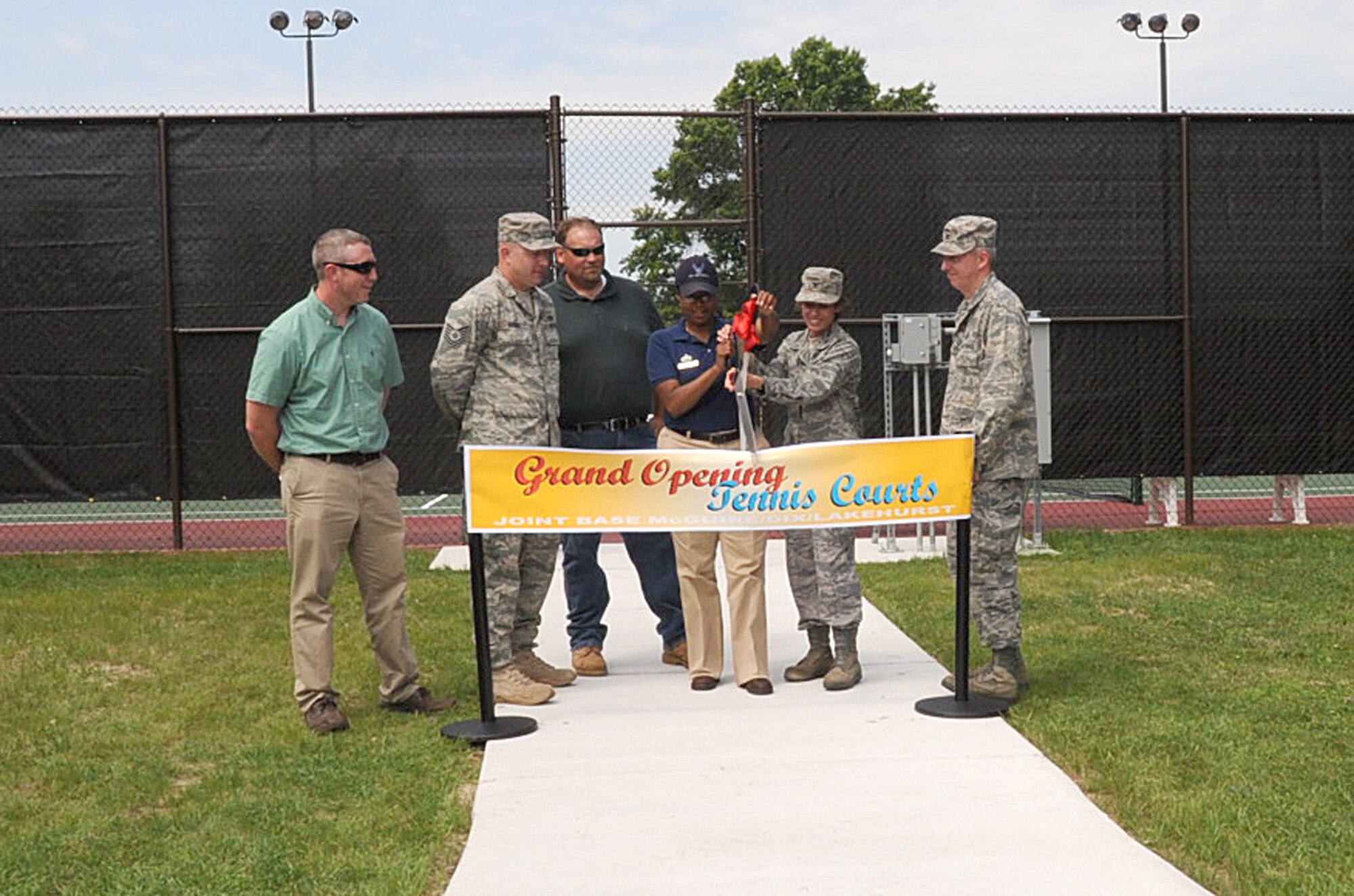 Joint Base McGuire-Dix-Lakehurst personnel, with Col. Gina Grosso, joint base installation commander, and Col. Michael Carrell, 87th Mission Support Group commander, opened new tennis courts near the Airman's Firehouse and McGuire Fitness Center in a ribbon-cutting ceremony July 8. (U.S. Air Force photo/Erin Blauvelt)