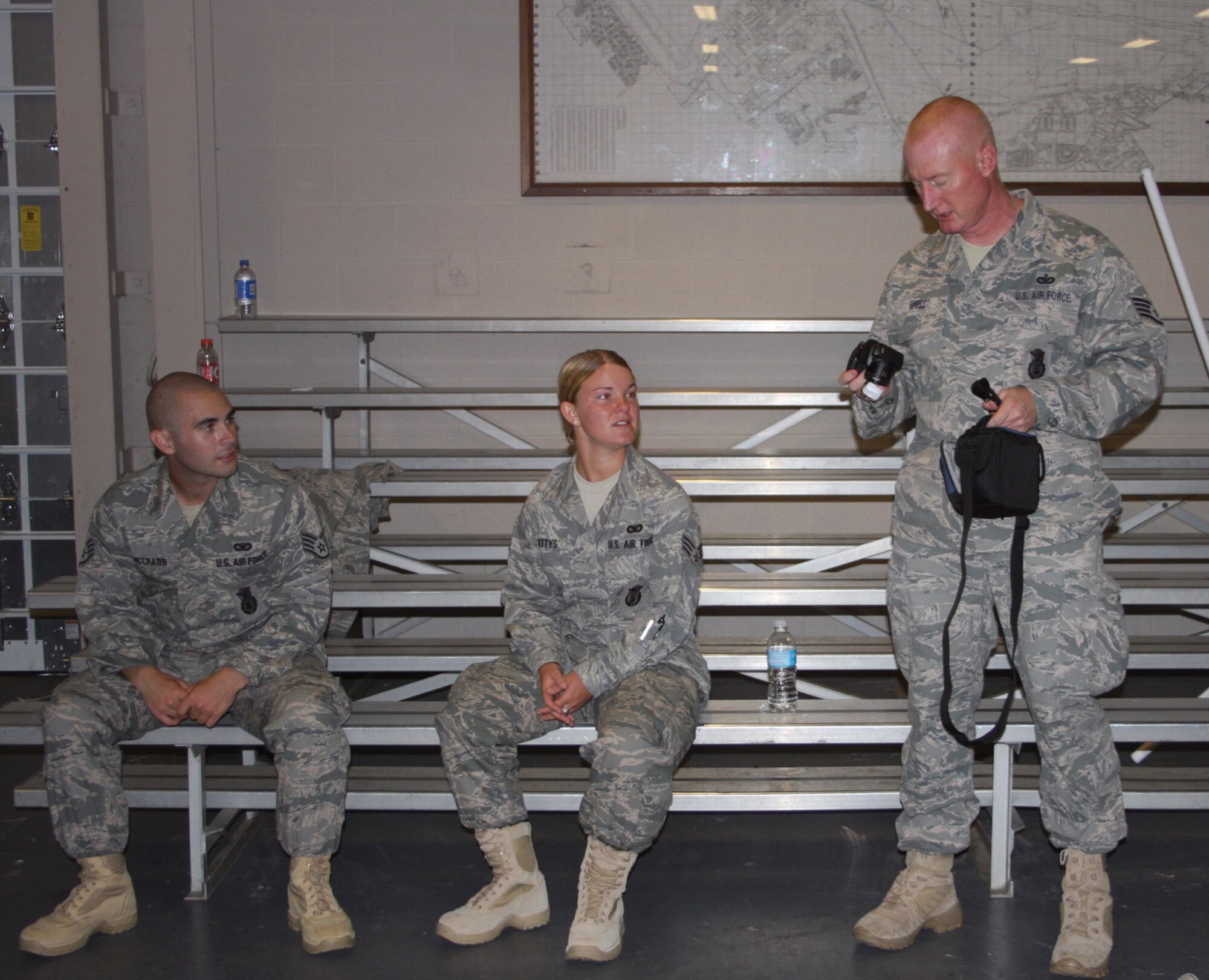 WRIGHT-PATTERSON AIR FORCE BASE, Ohio – Staff Sgt. Jude Snell, 445th Security Force Squadron, shows off his new camera to Staff Sgt. Joshua McCrabb and Senior Airman Dawn Gettys while they receive last minute instructions at the unit before deploying. The three deployed with 10 other reservists from the SFS to Kirkuk Regional Air Base, Iraq, July 6.  The group will be gone for six months. (Air Force photo/Stacy Vaughn)