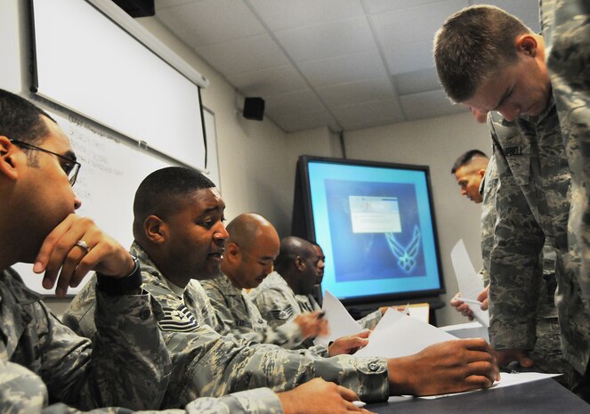 Tech. Sgt. Tony Rice performs a record review with Airman 1st Class Dustin Campbell, a recent technical school graduate, at a newcomer briefing here July 7. The in-processing documents are reviewed for promotion information and initial enlistment bonus as part of a processing line at the start of the briefing, ensuring personnel information remained accurate during permanent changes of station. Sergeant Rice is the NCO in charge of promotions with the Military Personnel Section and Airman Campbell is an aircrew flight equipment apprentice with the 437th Operations Support Squadron. (U.S. Air Force photo/Staff Sgt. Daniel Bowles)
