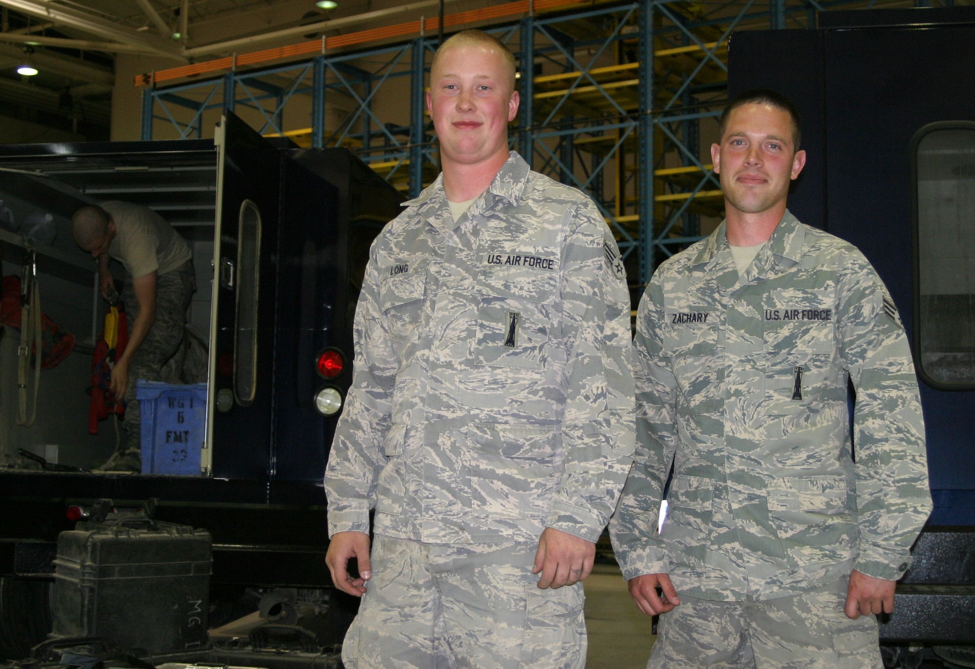 Senior Airmen Kyle Long and Christopher Zachary, 341st Maintenance Operations Squadron, pose inside Malmstrom's 3-bay hangar. (U.S. Air Force photo/Senior Airman Dillon White) 