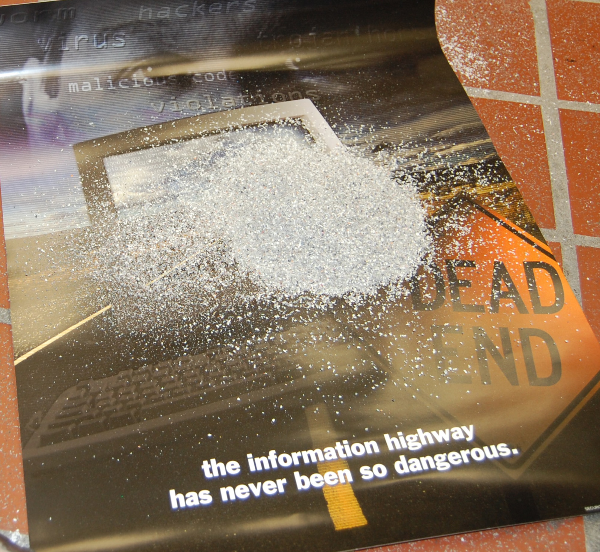 Wesley Speth, 341st Missile Wing information assurance analyst, gets ready to drop a piece of a cell phone into a disintegrator. The phone was destroyed because it was used improperly. According to Air Force Systems Security Instruction 8502, the use of privately-owned information systems to process or store critical unclassified information and personally identifiable information is not allowed. Privately-owned information systems contaminated with these types of information will be confiscated and sanitized according to directives. In this case, the only means of sanitation was destruction.